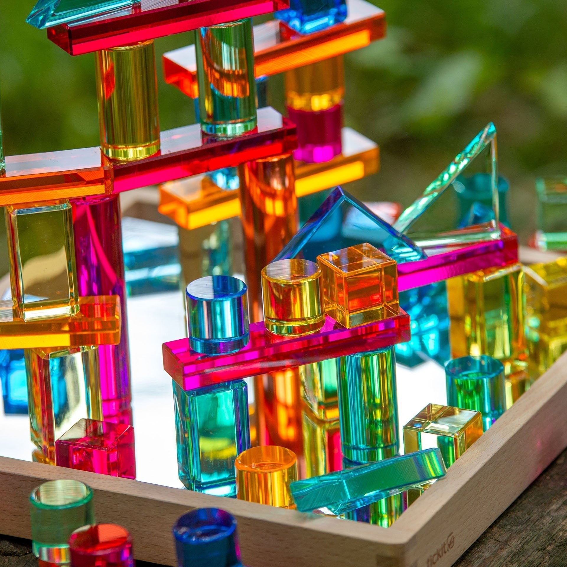 Colorful transparent building blocks on a wooden base