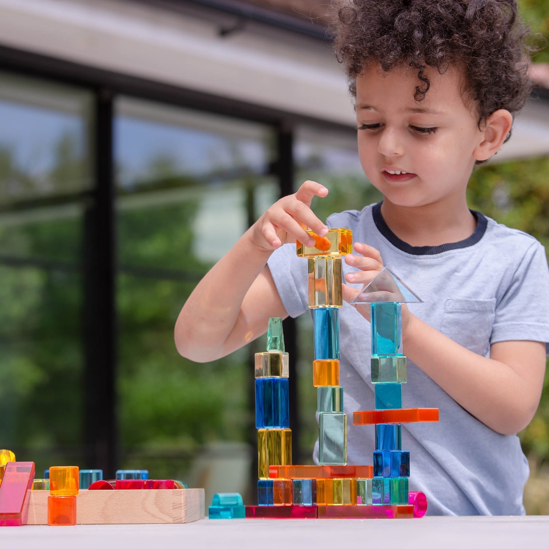 Child playing with colorful building blocks outdoors