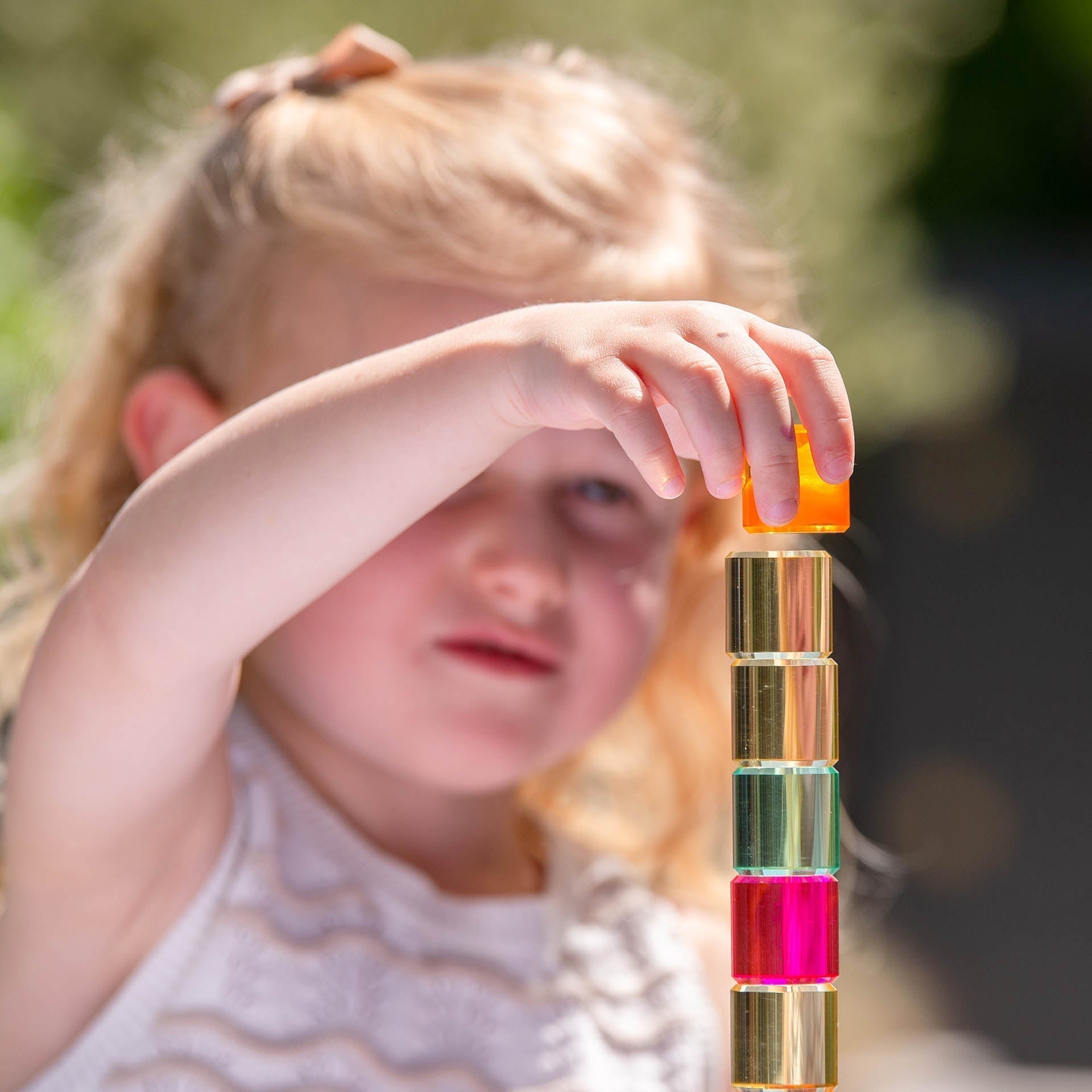 Child playing with colorful building blocks outdoors