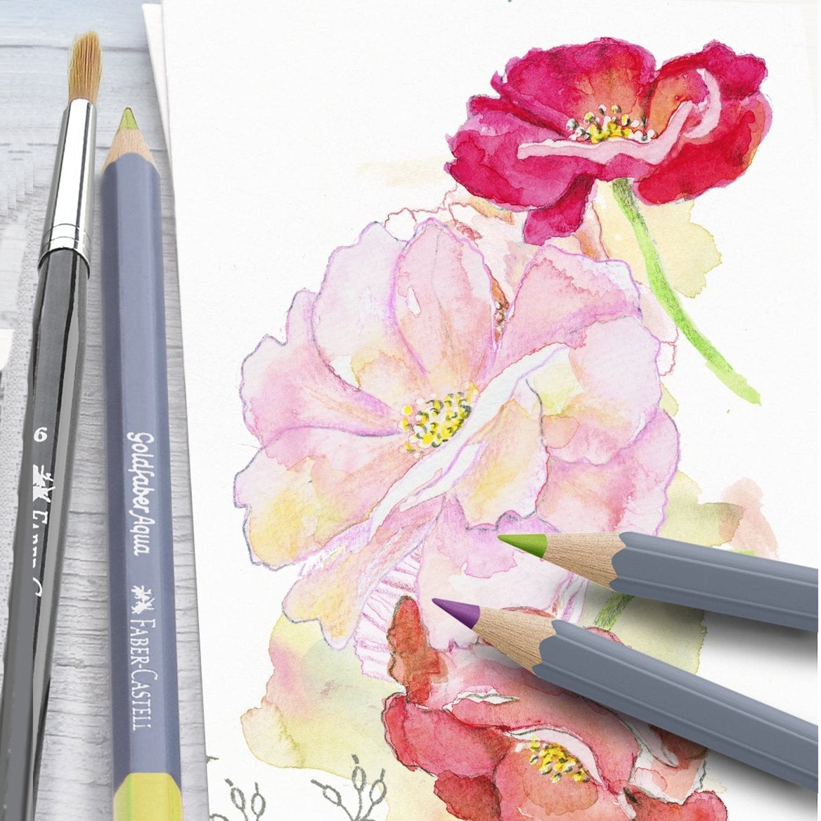 Coloring book with floral design and colored pencils on a white surface