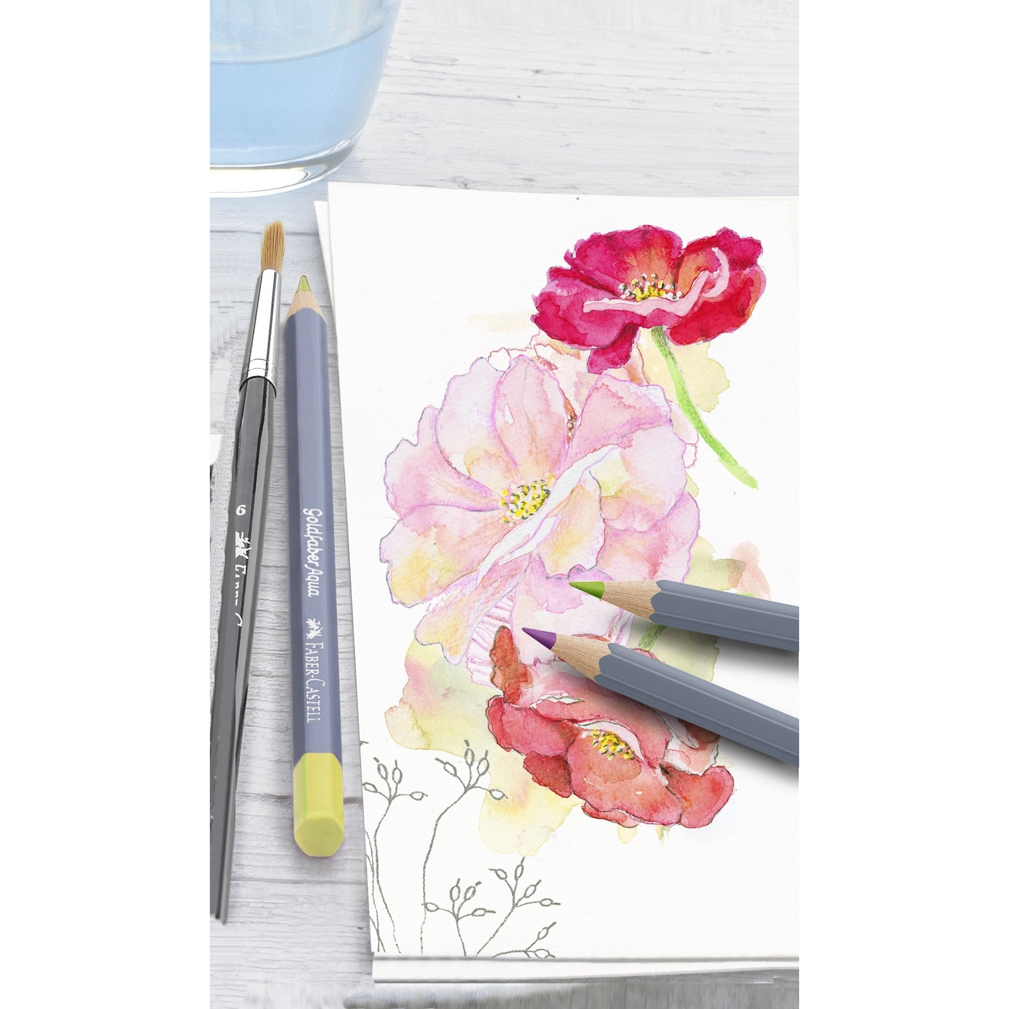 Coloring book with floral design and colored pencils on a white surface