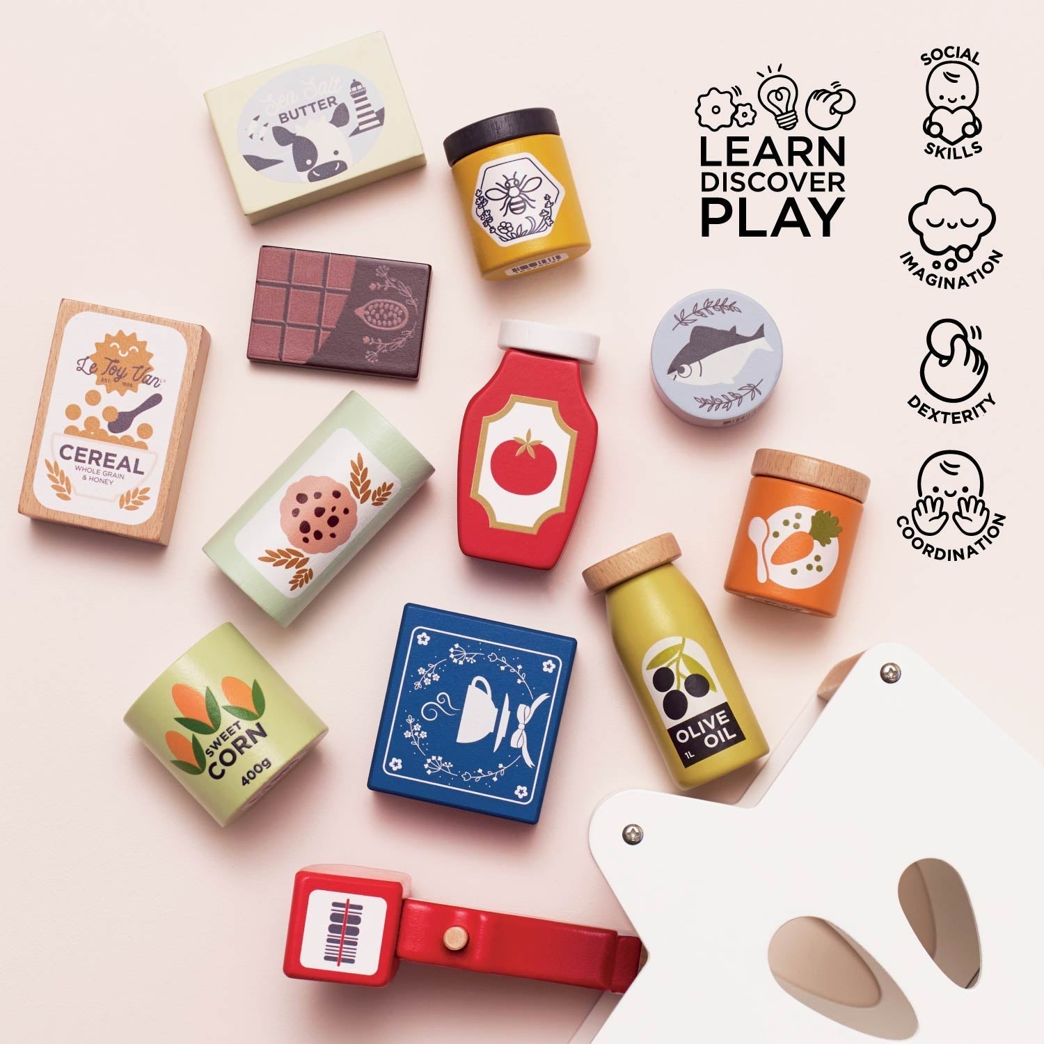 Colorful toy food items and kitchen accessories on a light pink background with 'Learn Discover Play' text and icons.