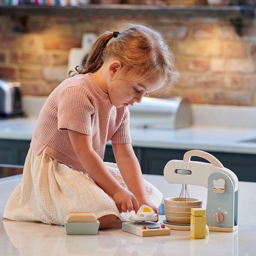 Child playing with toy kitchen set on a countertop