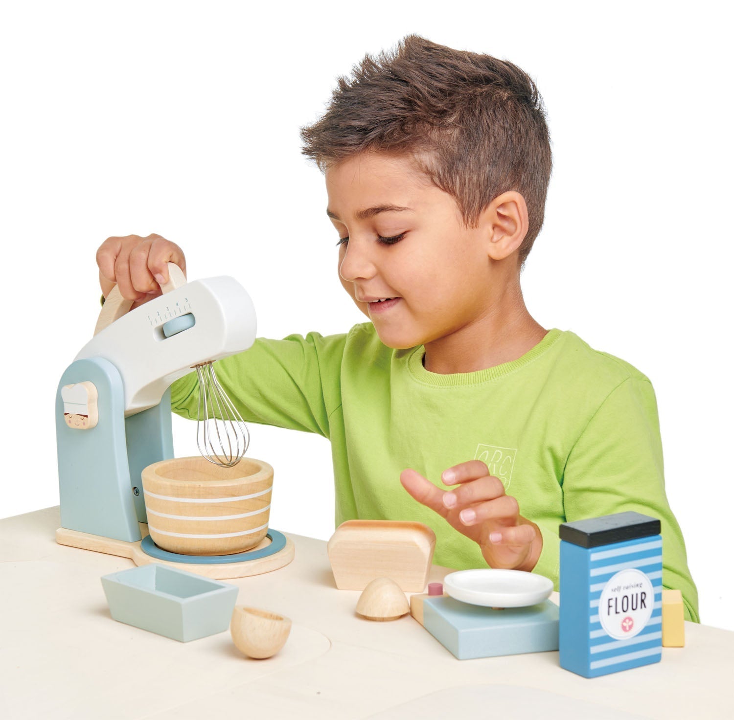 Child playing with a toy kitchen set on a white background