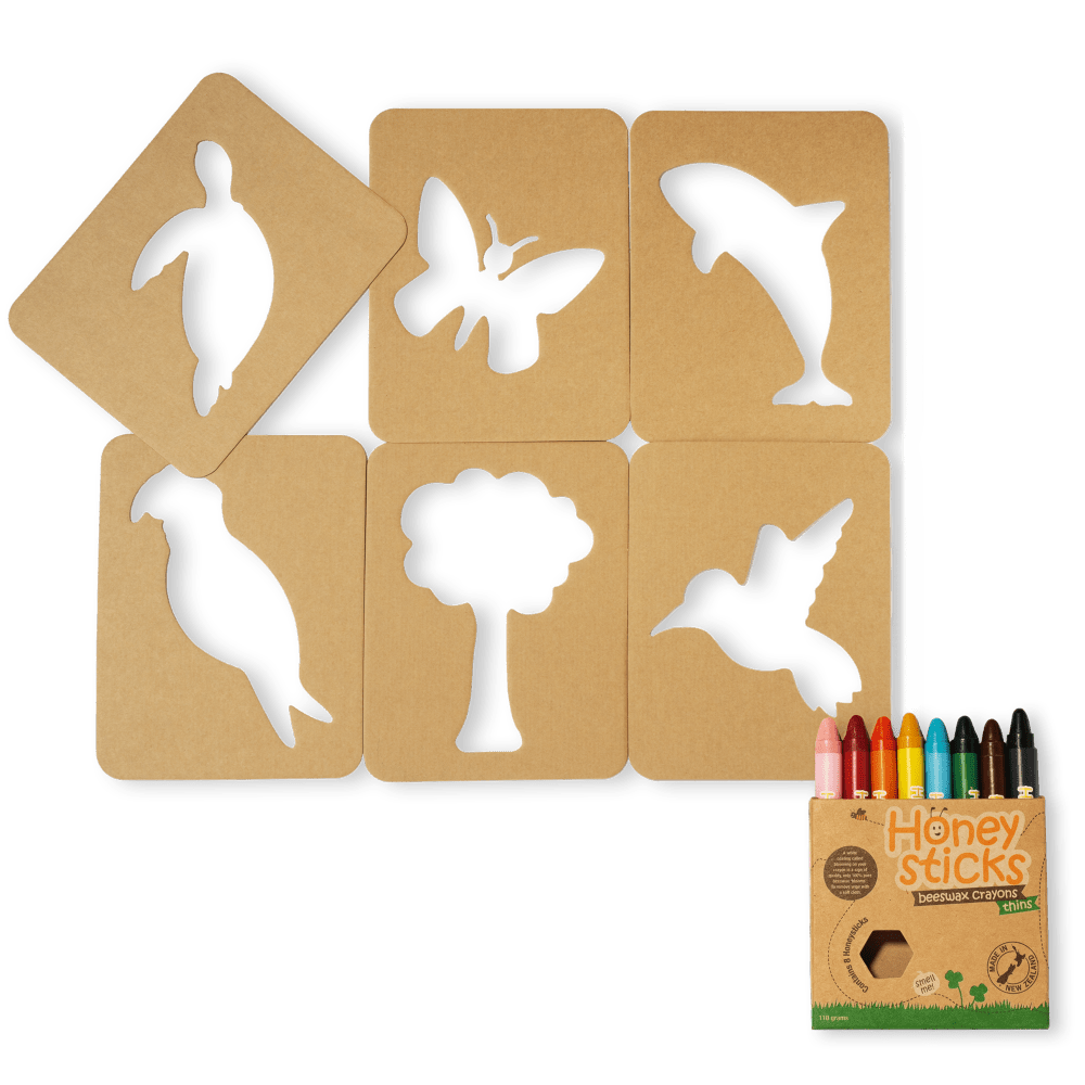 Set of cardboard stencils with animal shapes and a box of crayons on a white background
