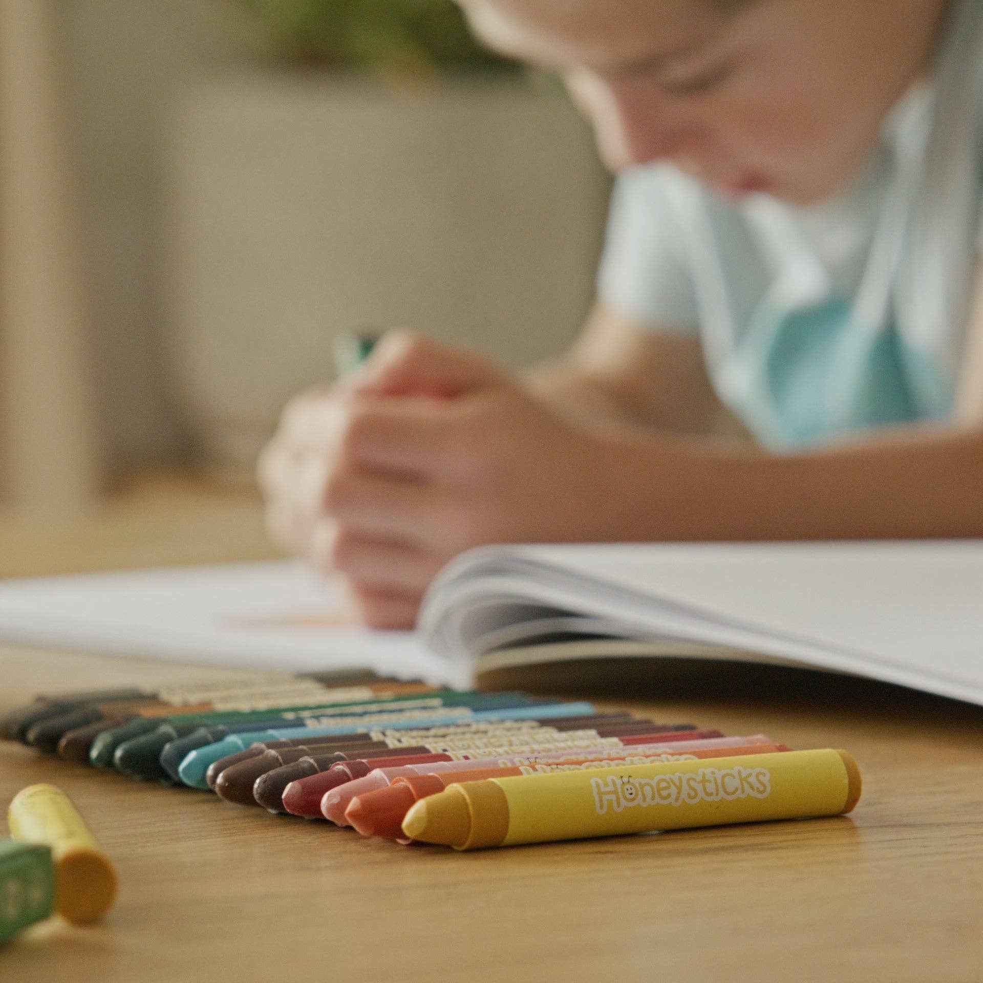 Child drawing with crayons on a table