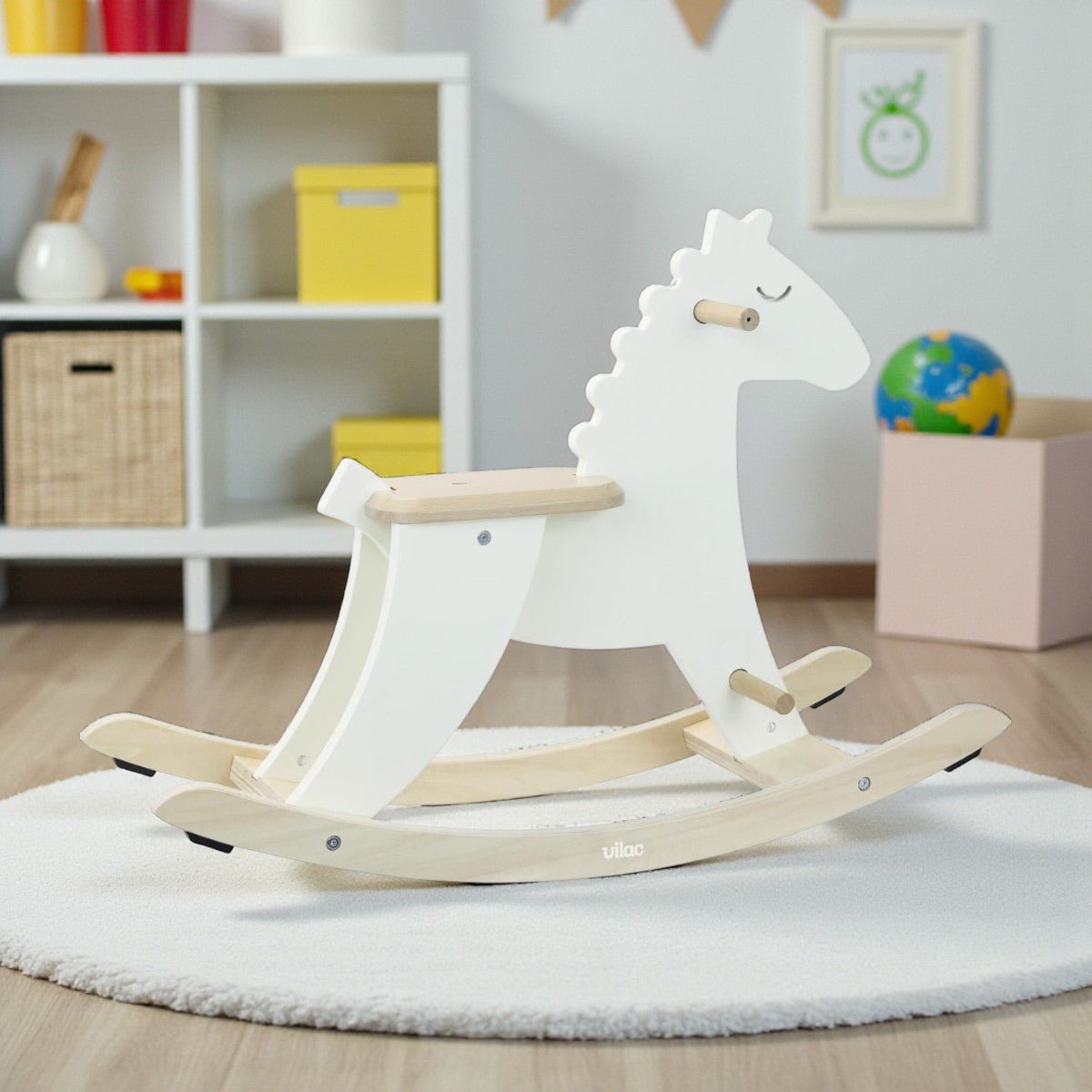 White rocking horse toy on a rug in a room with shelves and toys.