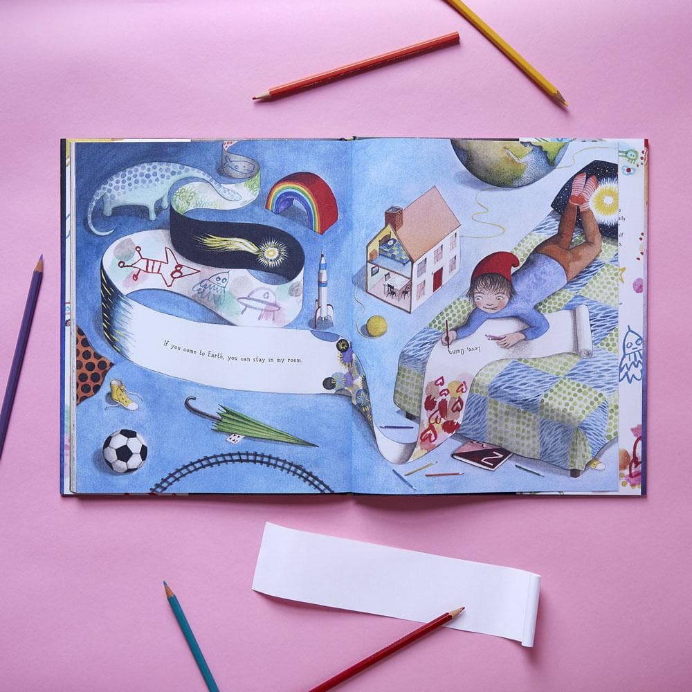 Illustrated book open to a page with colorful drawings on a pink background