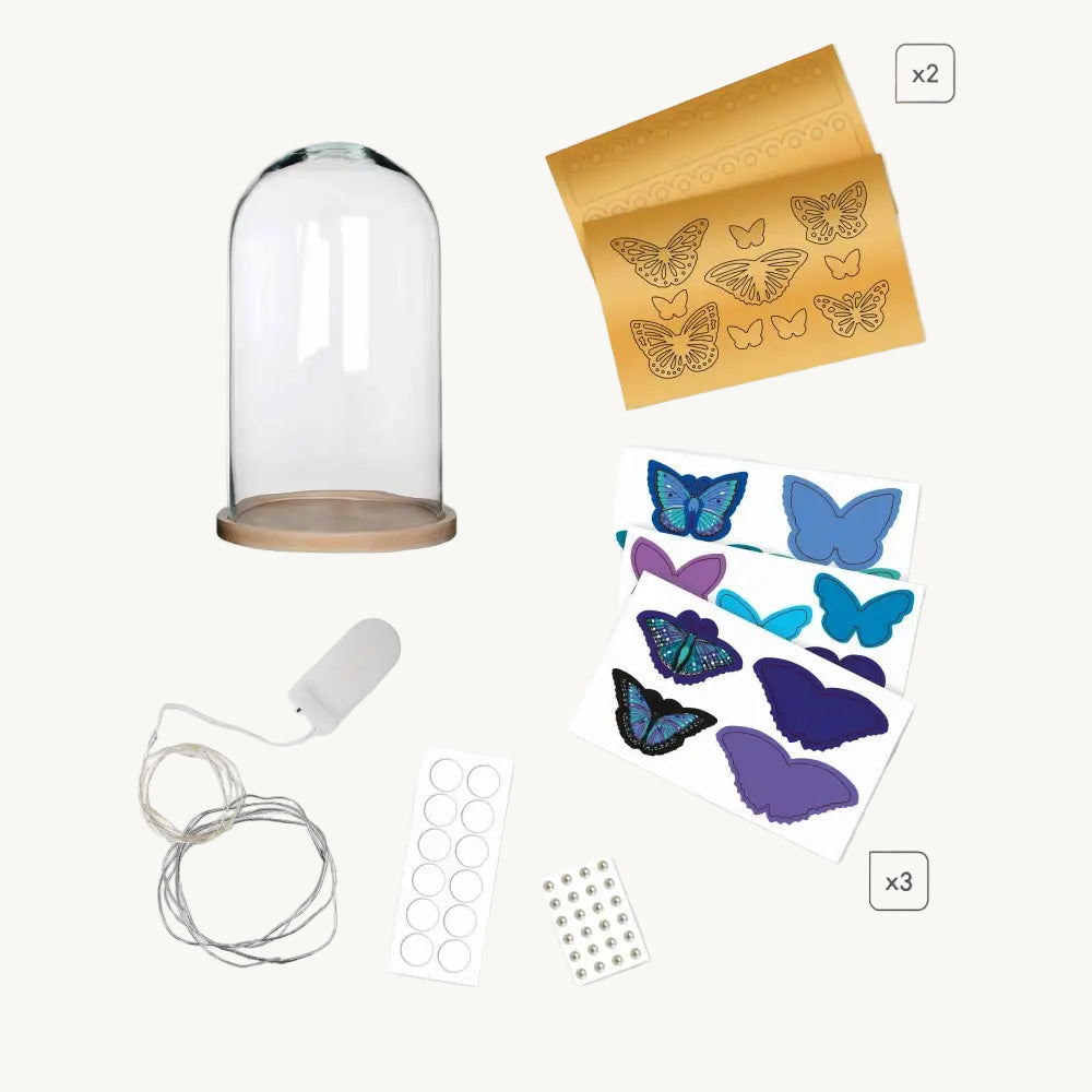 Collection of butterfly-themed items including a glass dome, stamp set, and decorative stickers on a white background.
