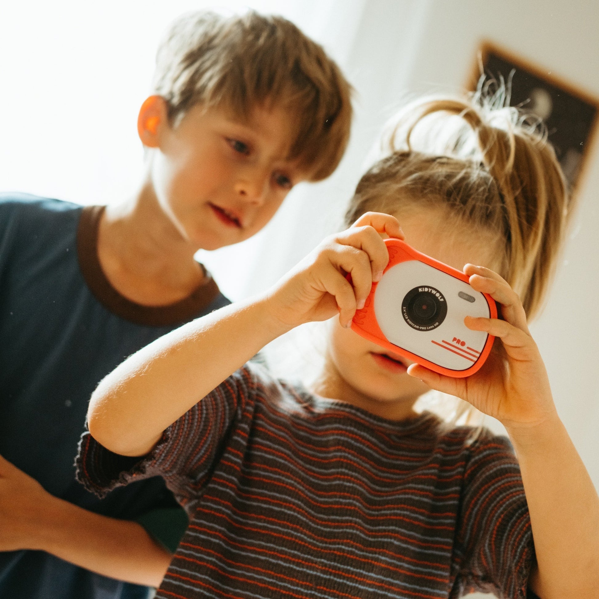 Two children looking at a toy camera together