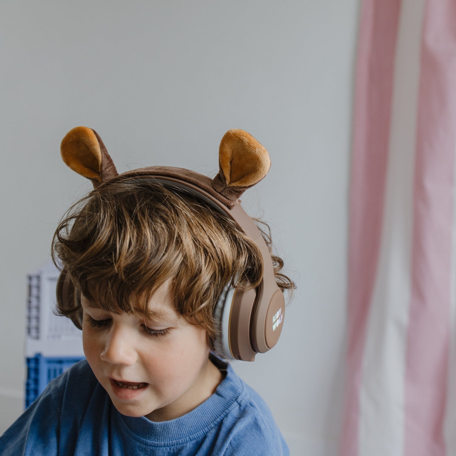 Child wearing brown headphones with animal ears against a light background
