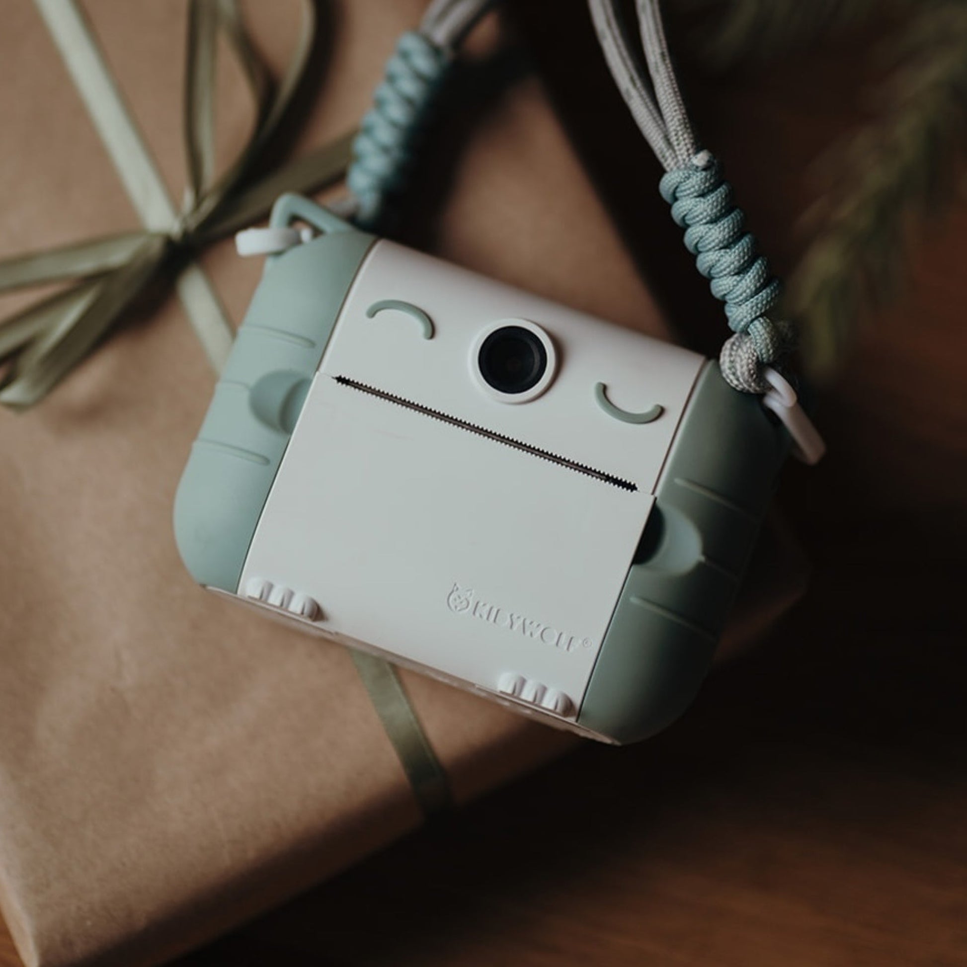 Small camera-shaped pouch with a face design on a brown surface
