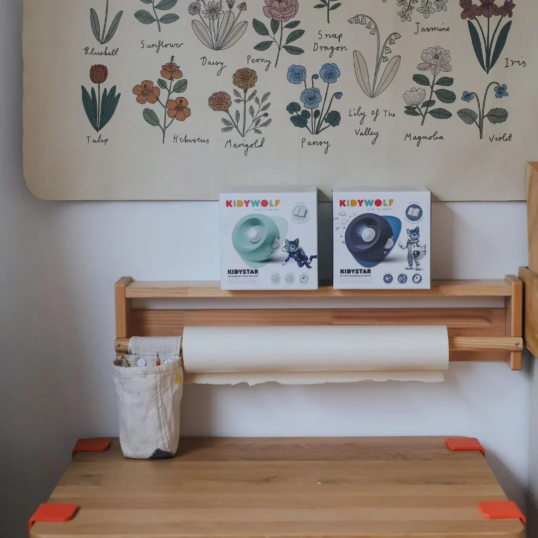Wooden shelf with Kibywolf products against a wall with floral illustrations.