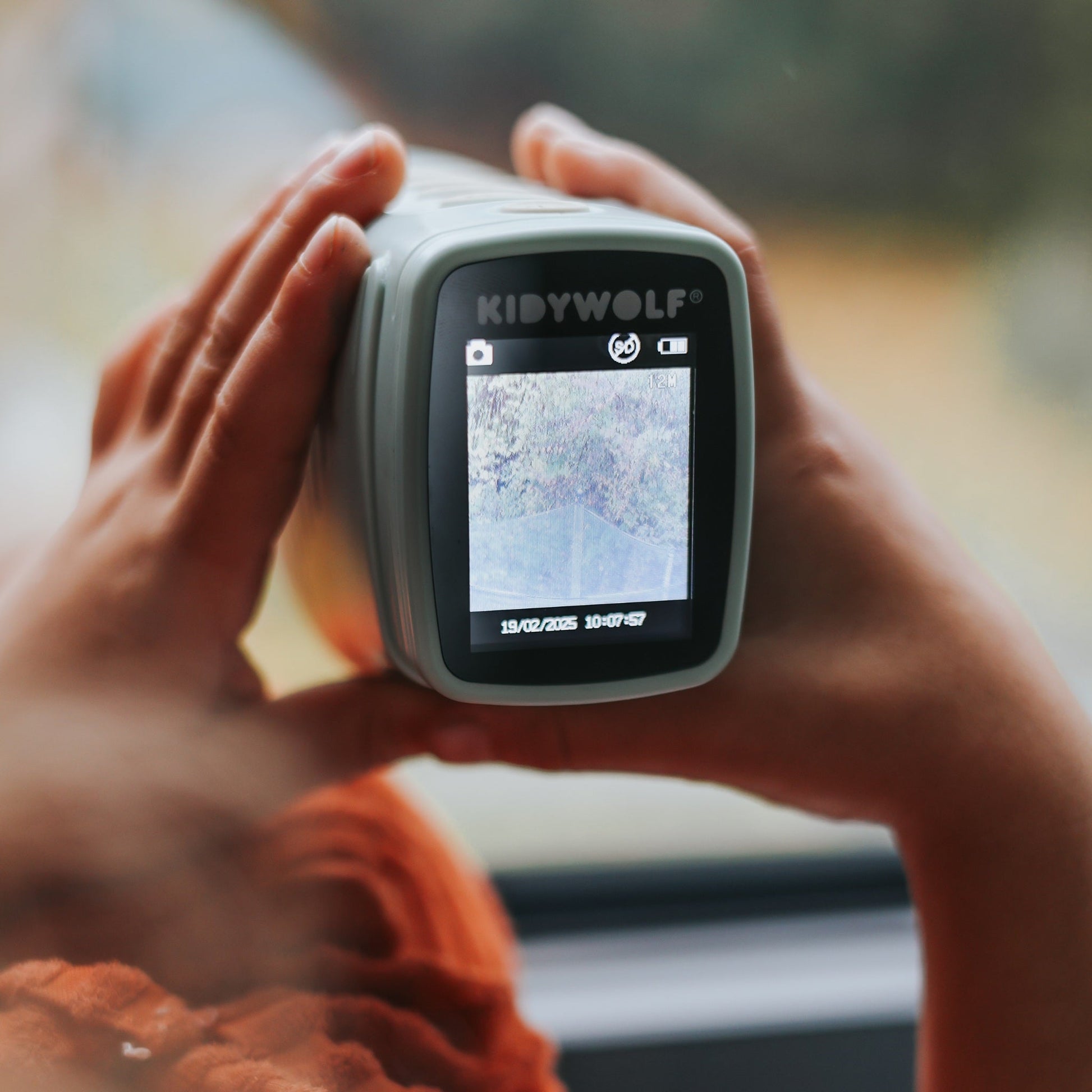 Person holding a device with a screen displaying a map, brand 'KIDYWOLF' visible