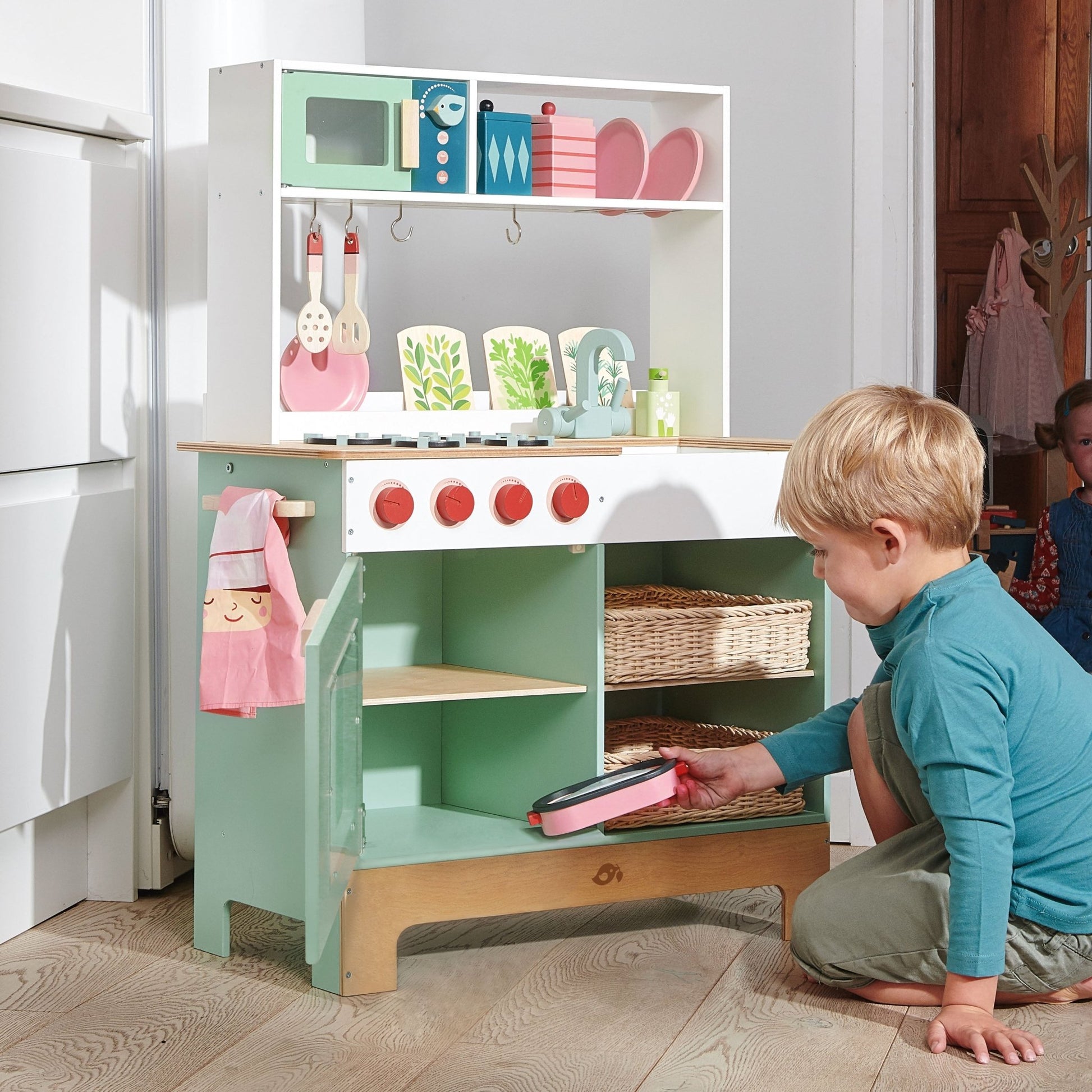 Child playing with a toy kitchen set in a home setting