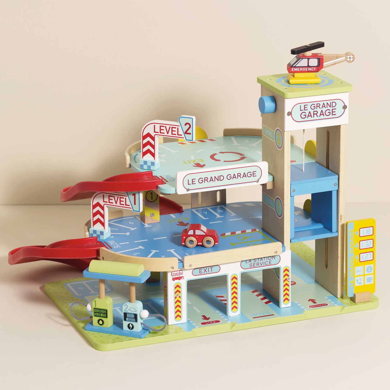 Wooden toy garage with multiple levels and a helicopter on top, on a beige background.