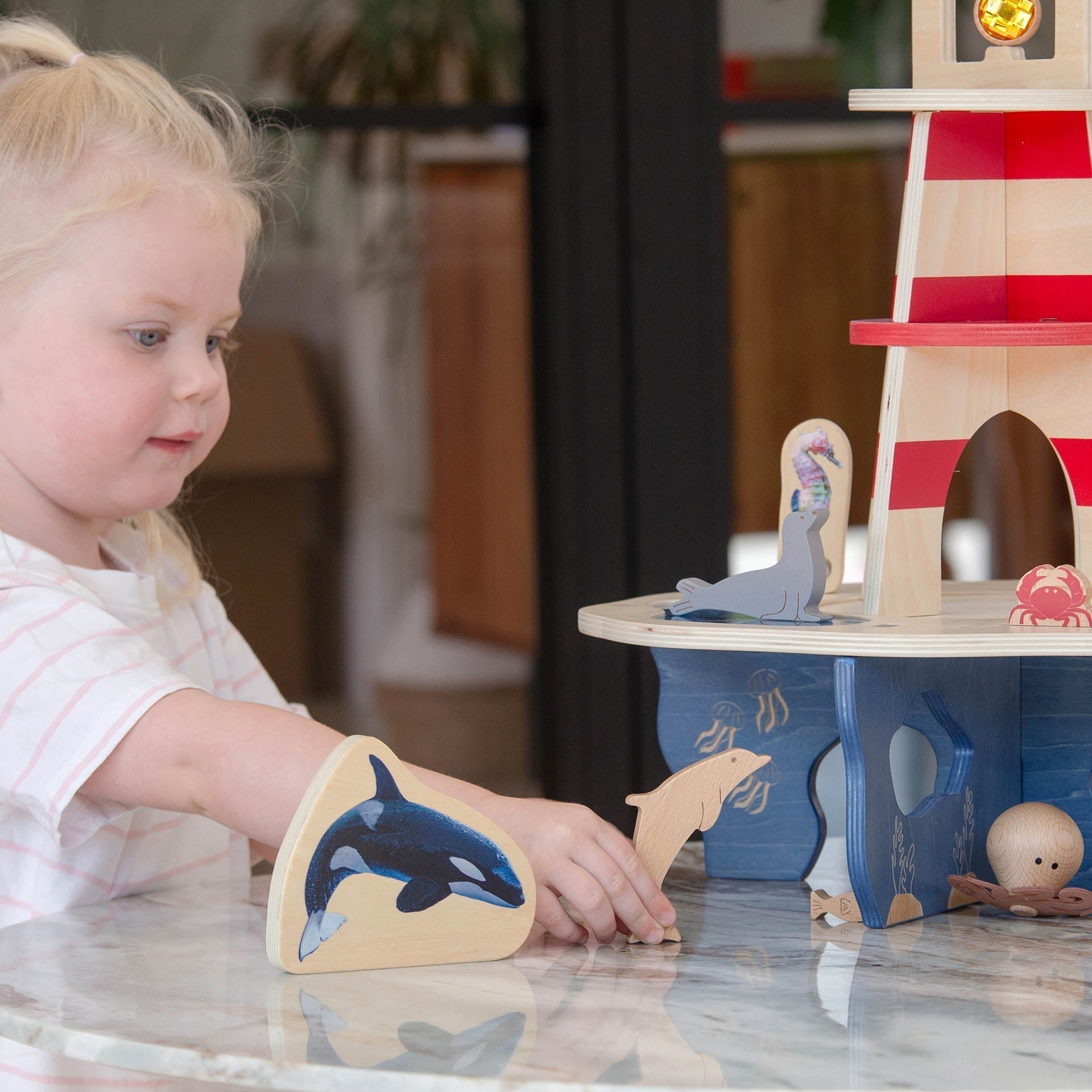Child playing with wooden animal toys on a table
