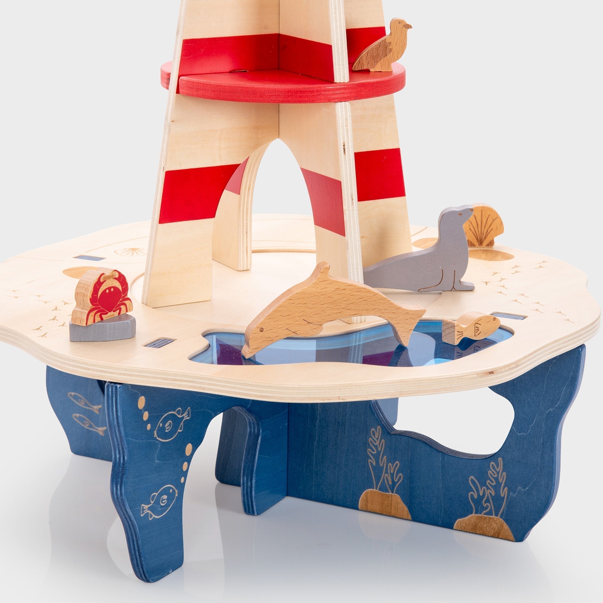 Wooden toy lighthouse with animals on a white background