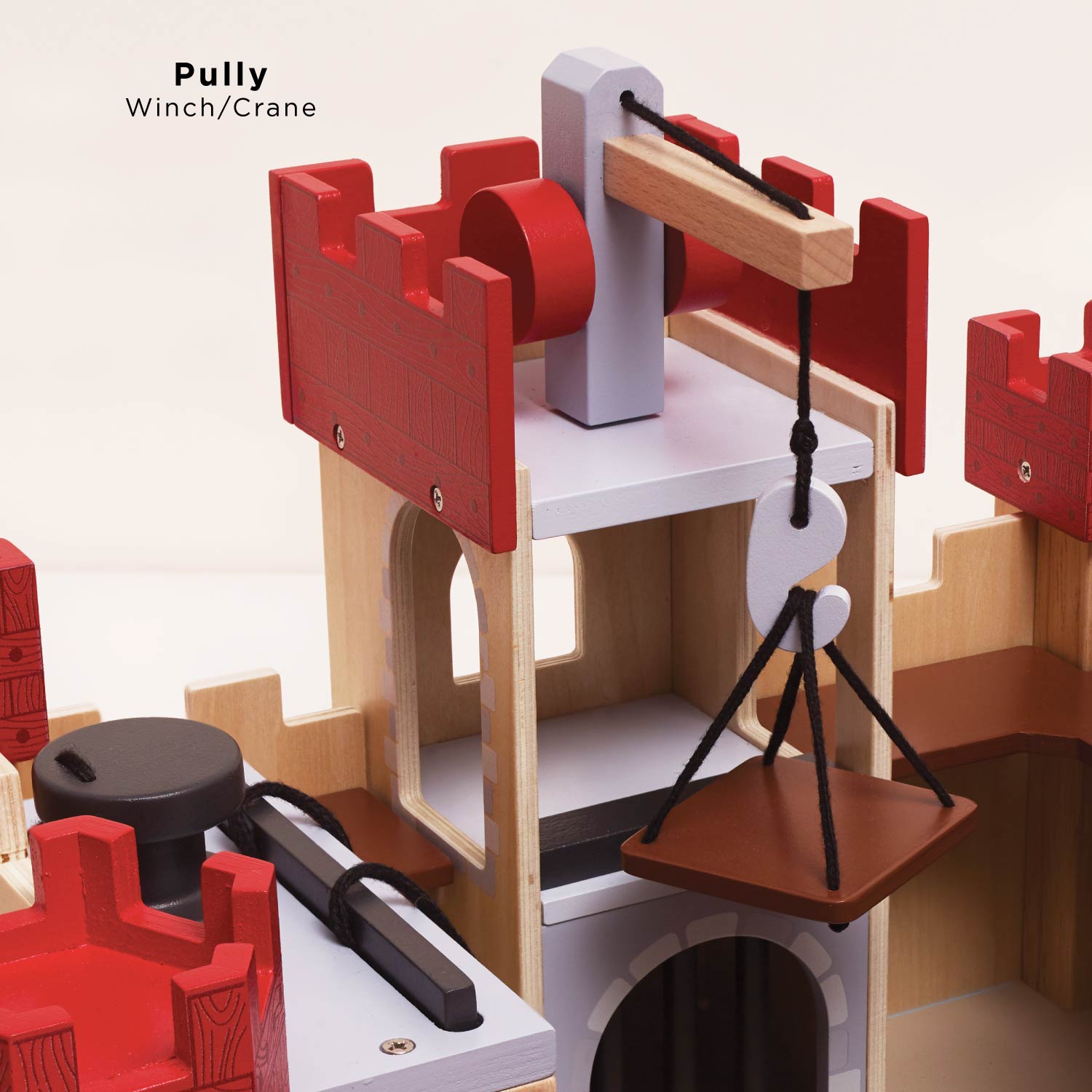 Wooden pulley system toy with red and gray components on a beige background