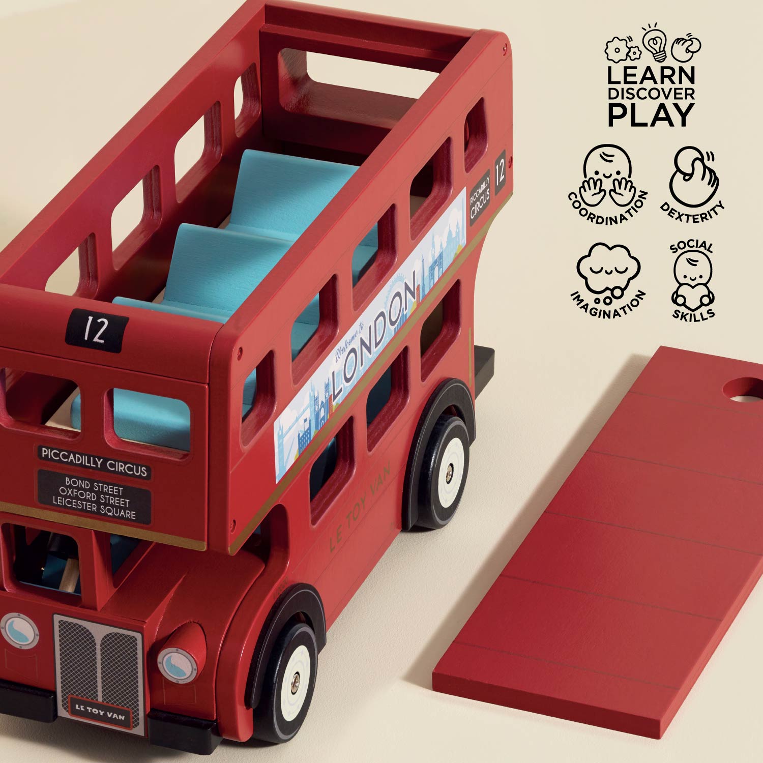Red toy double-decker bus with a blue interior on a beige background, featuring 'Learn Discover Play' icons.
