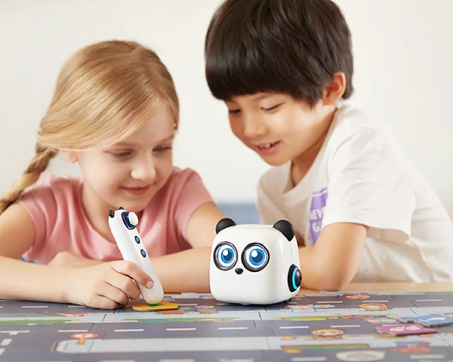 Two children playing with a robot toy on a carpeted floor.