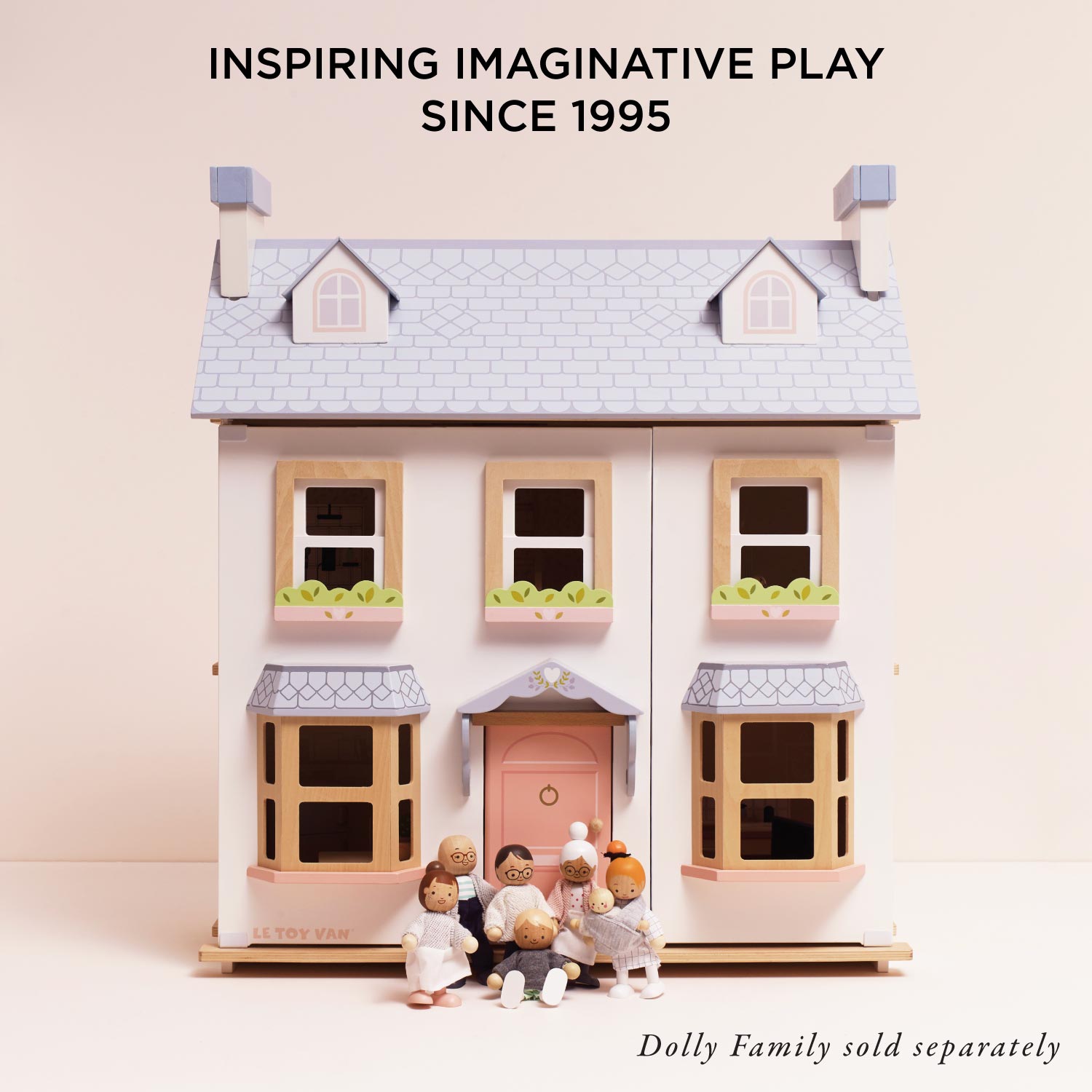 Toy house with miniature figures on a light pink background, featuring text about imaginative play.