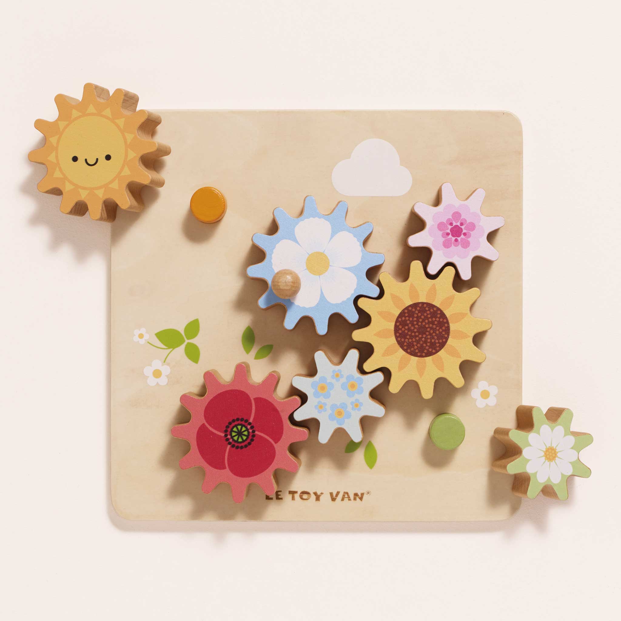 Wooden toy with colorful gears shaped like flowers and a sun on a beige background