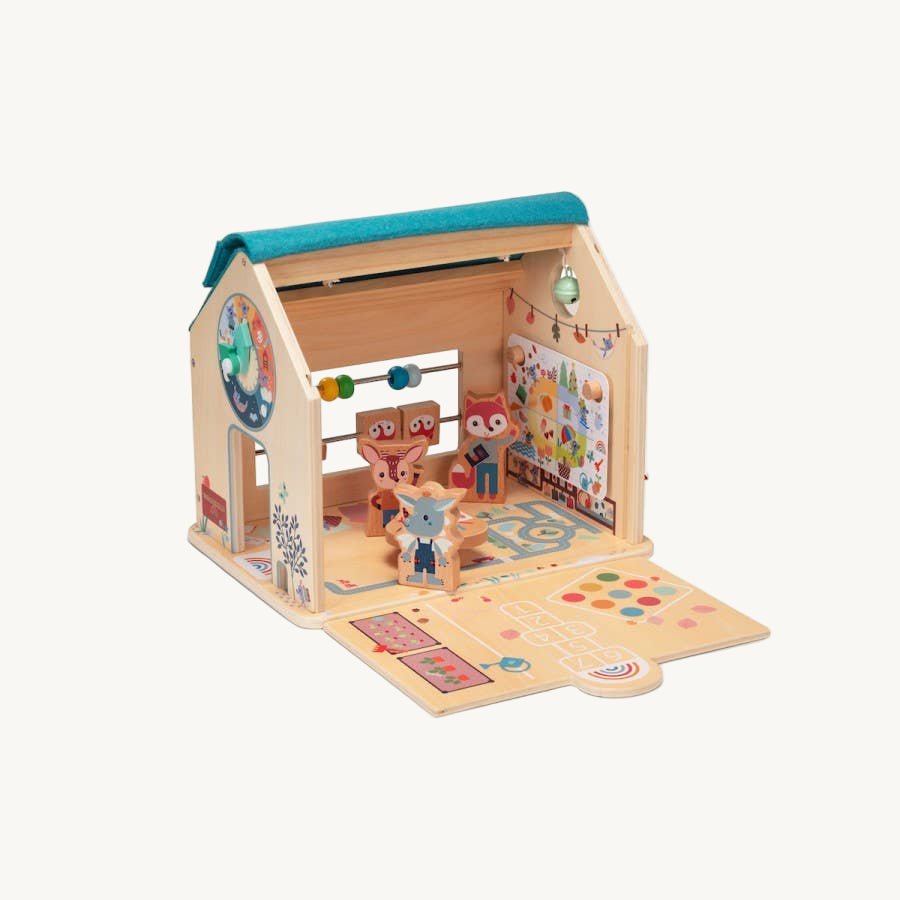 Toy playhouse with wooden figures and colorful decorations on a white background