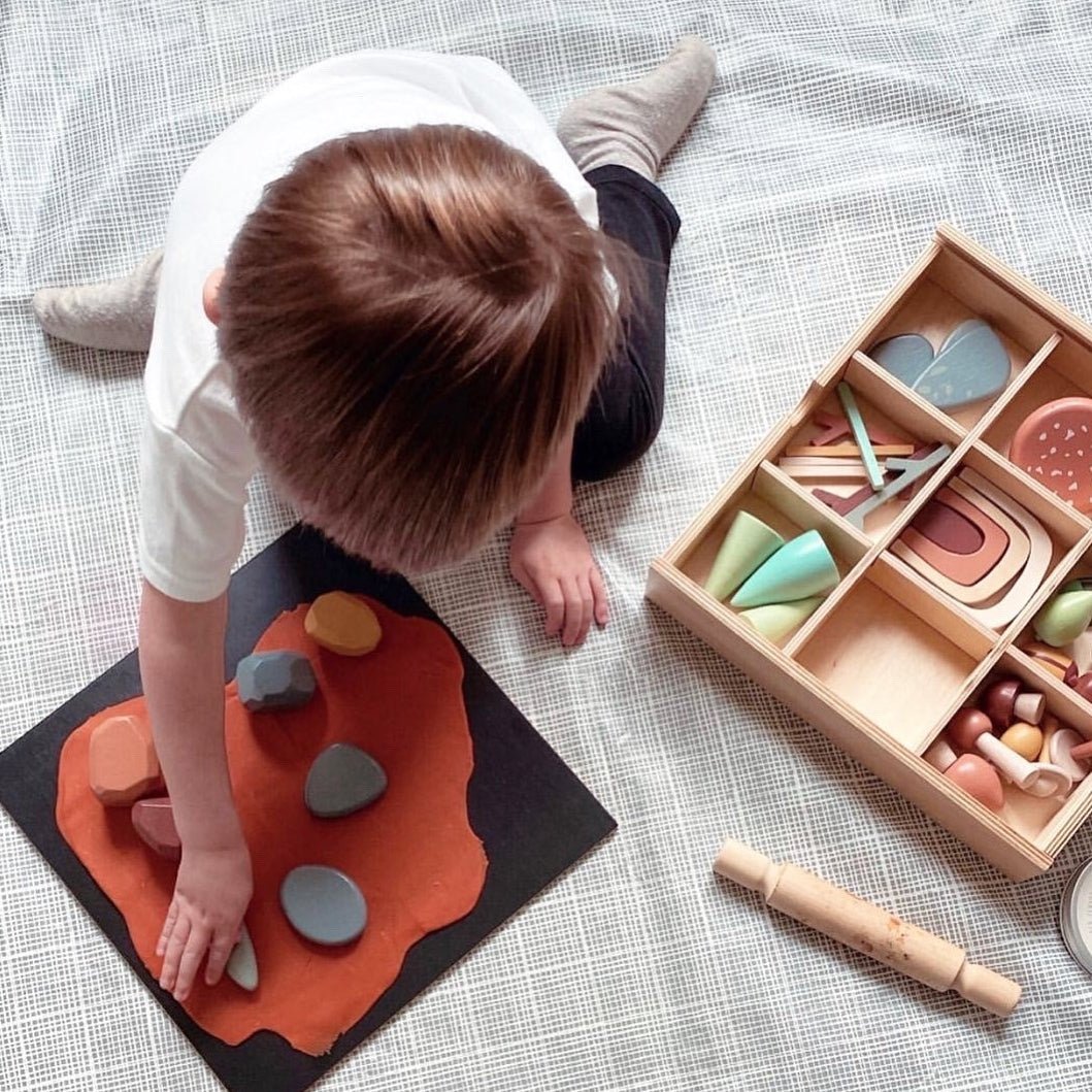 Child playing with wooden toys on a checkered floor