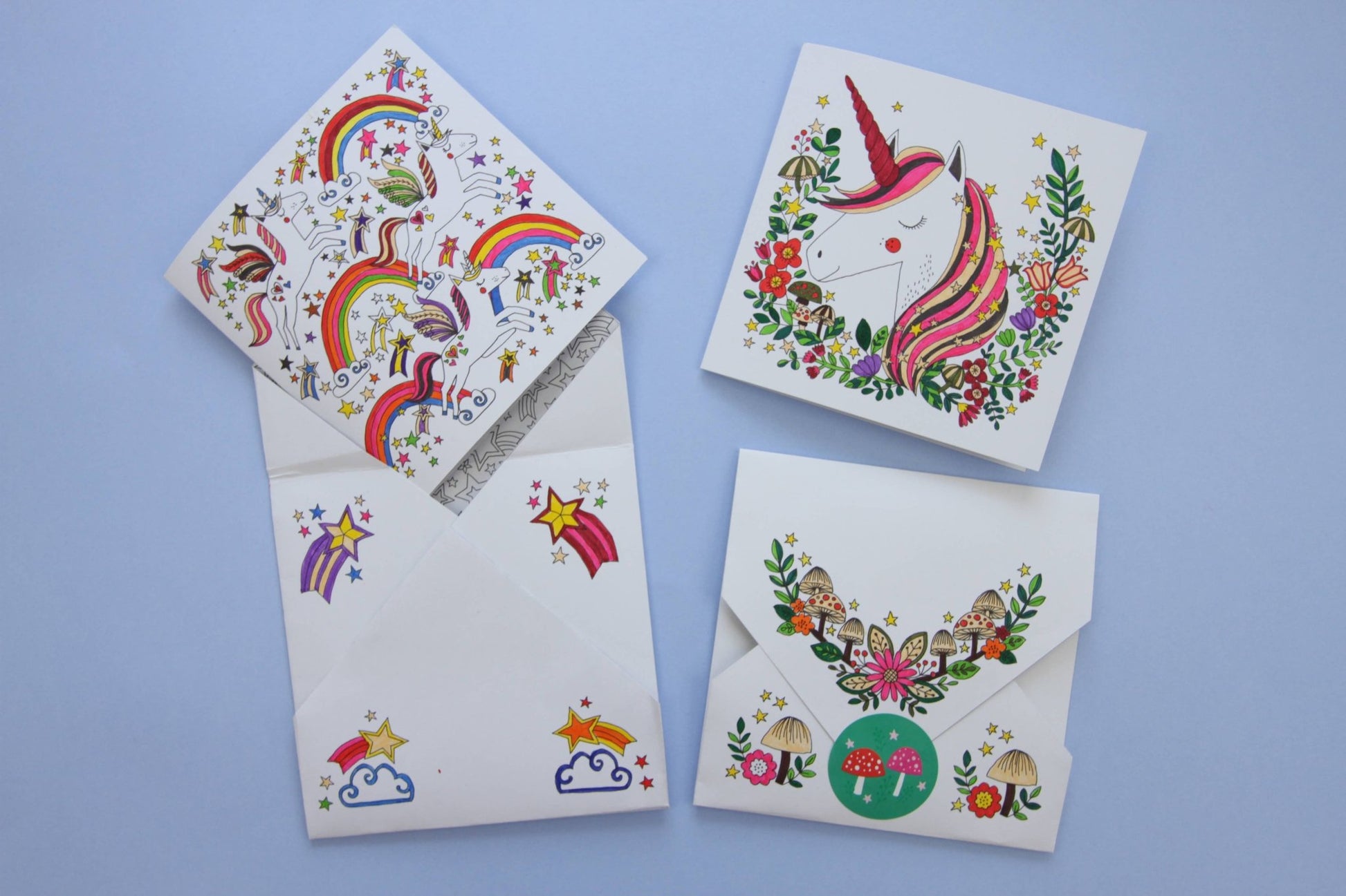 Set of four greeting cards with colorful designs on a blue background