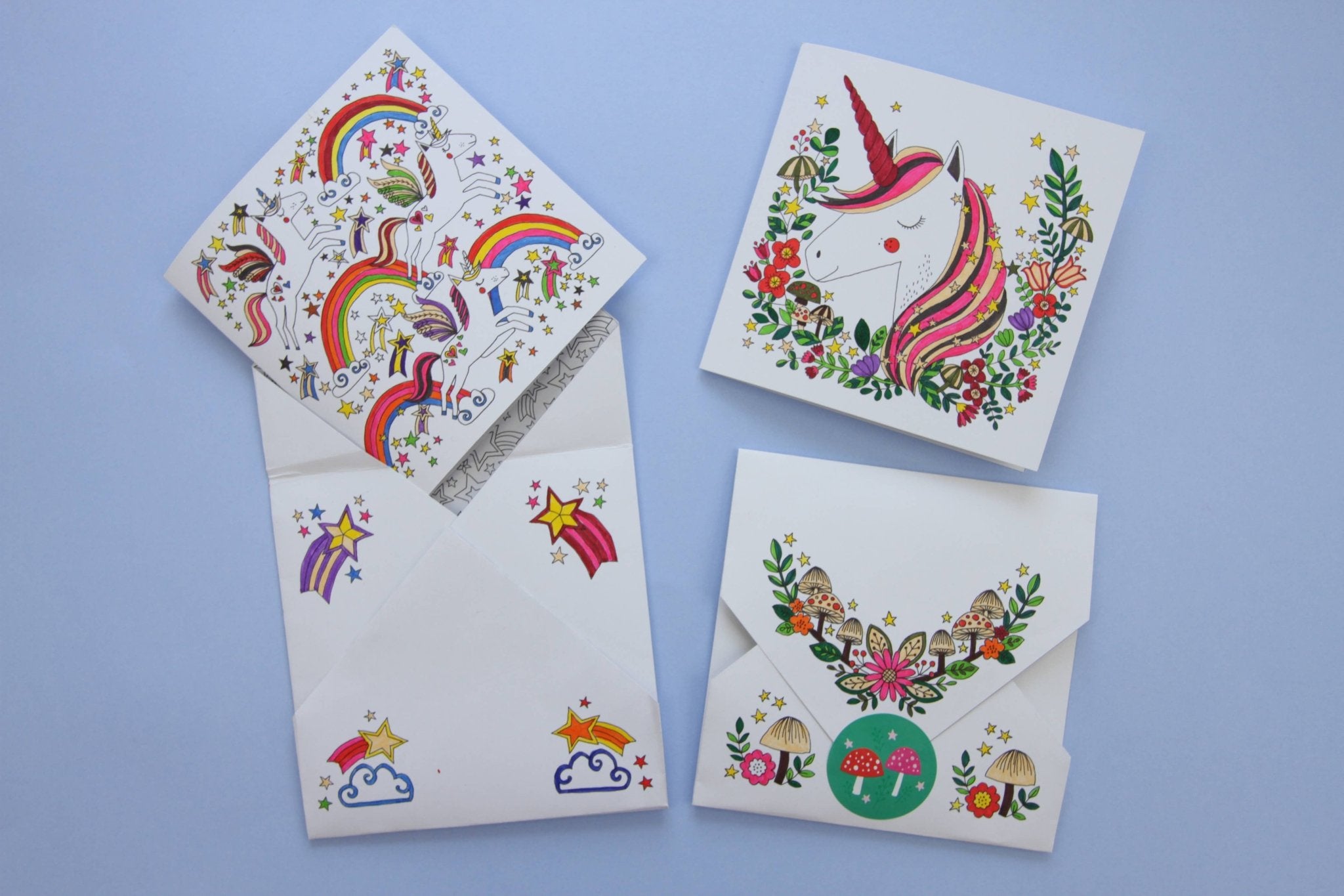 Set of four greeting cards with colorful designs on a blue background