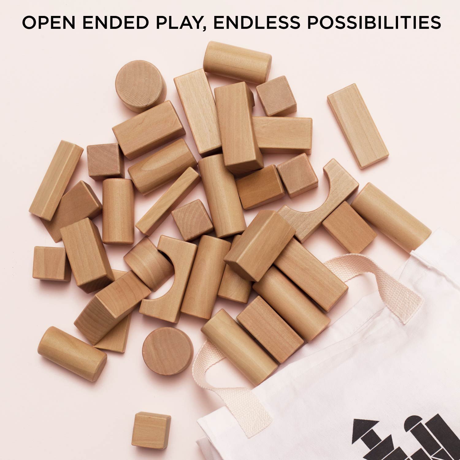 Wooden building blocks scattered on a light surface with 'Open Ended Play, Endless Possibilities' text above.