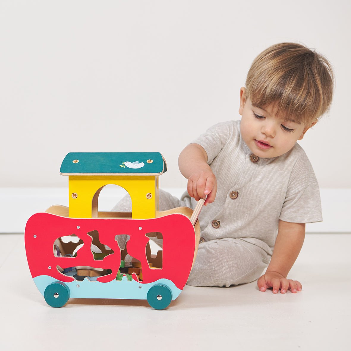 Child playing with a colorful wooden toy on a white background