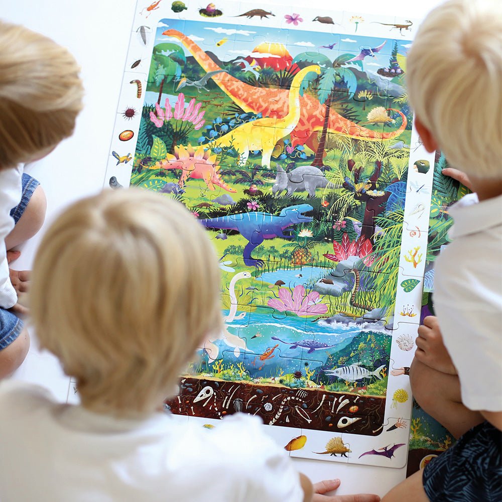 Children looking at a dinosaur-themed poster