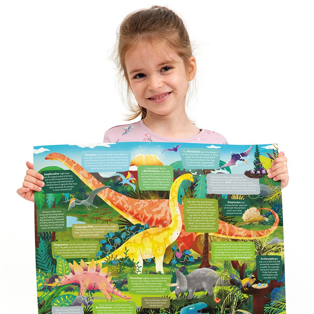 Child holding a colorful dinosaur poster with illustrations and text.