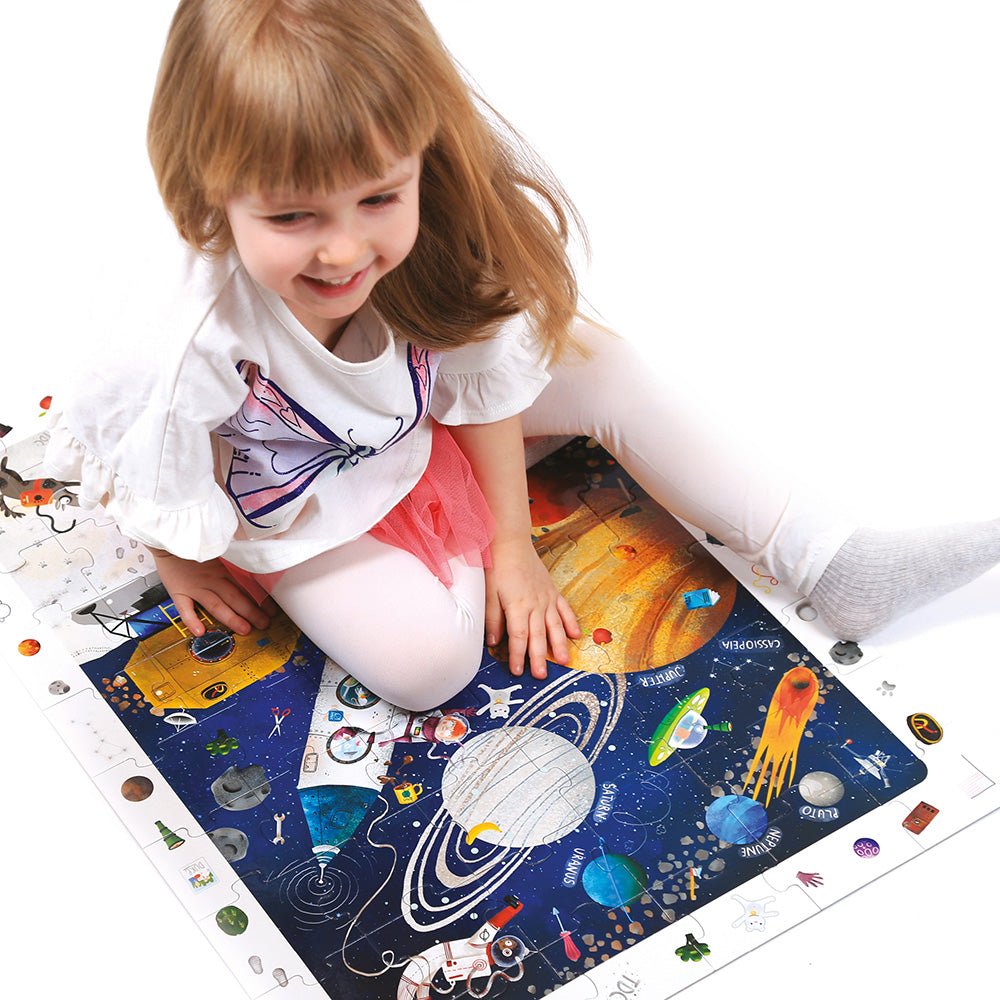 Child playing with a solar system-themed mat on a white background