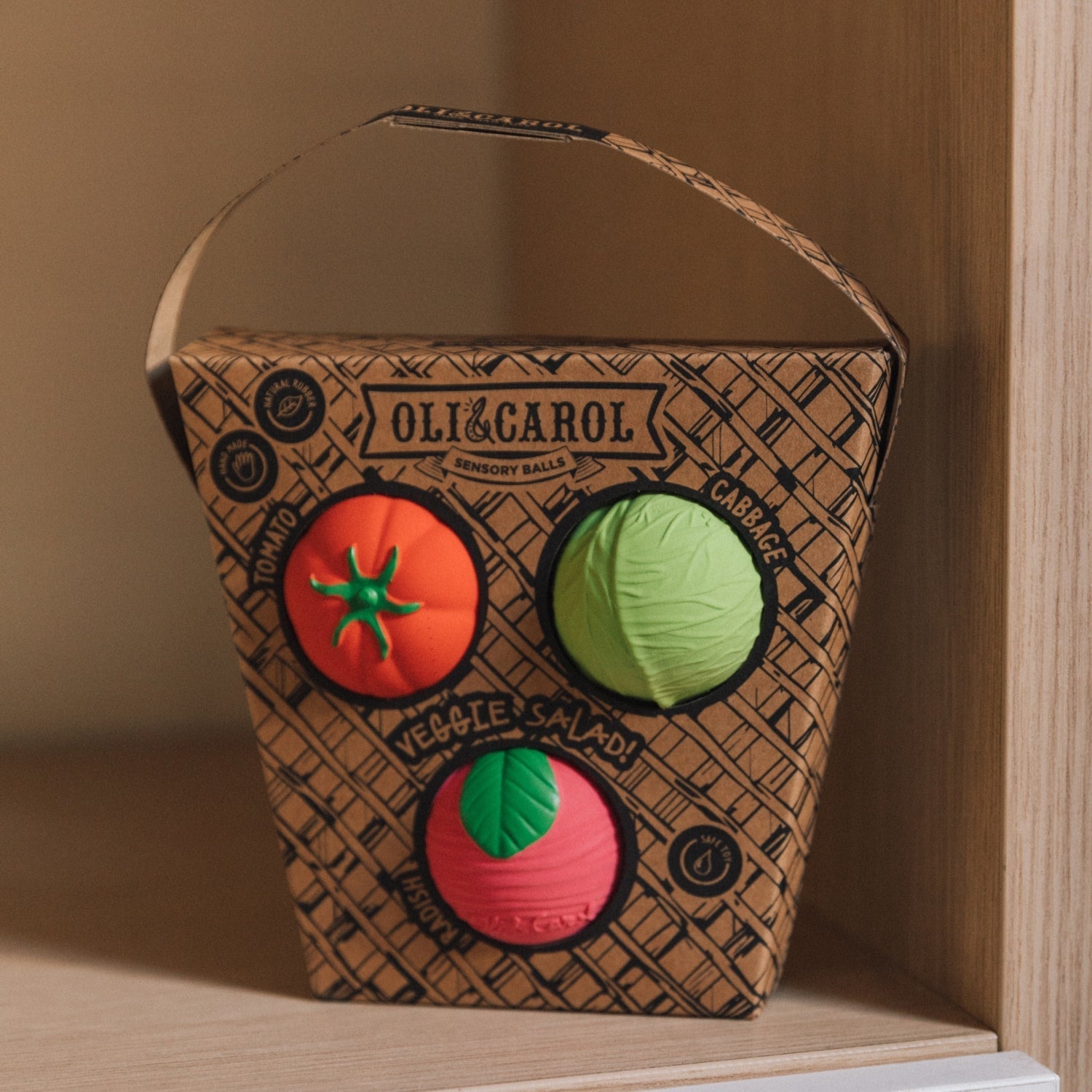 Cardboard box with toy vegetables on a wooden shelf