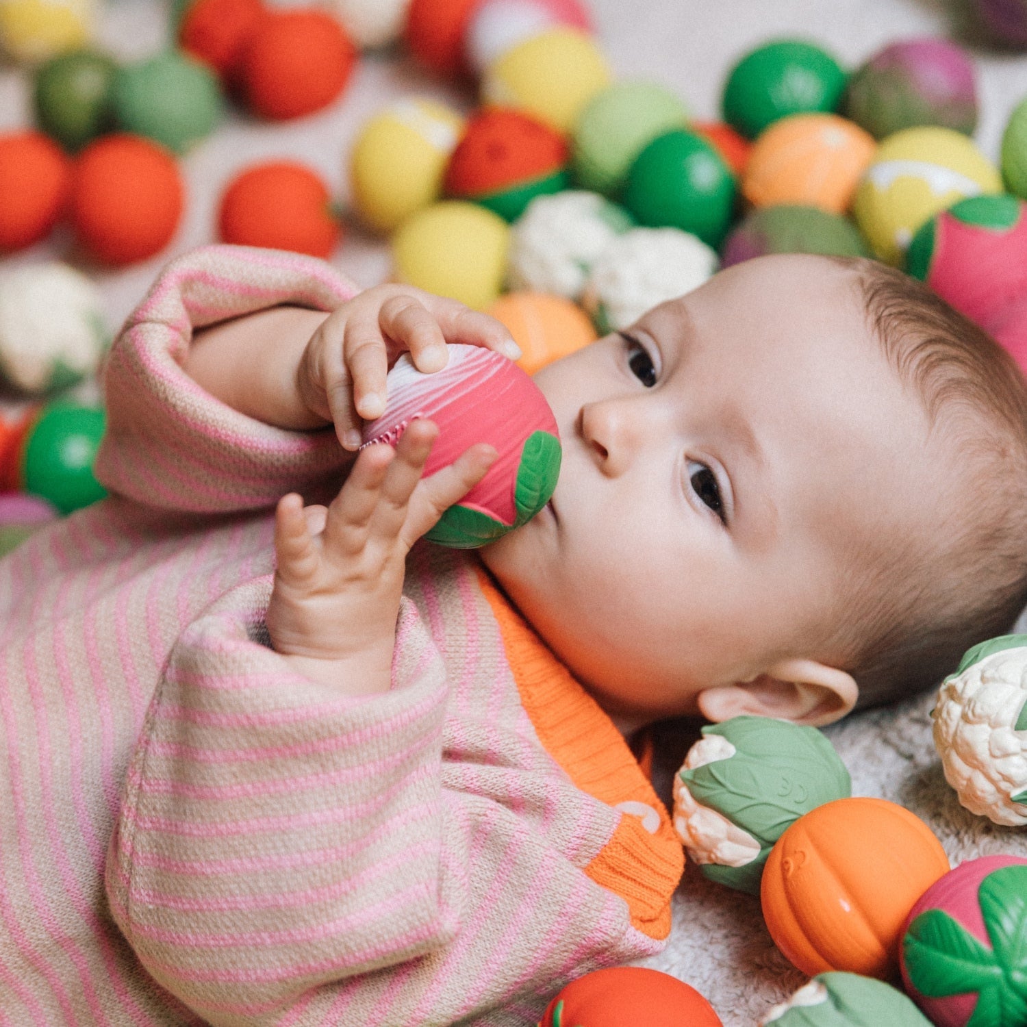 Baby playing with colorful toys in a ball pit