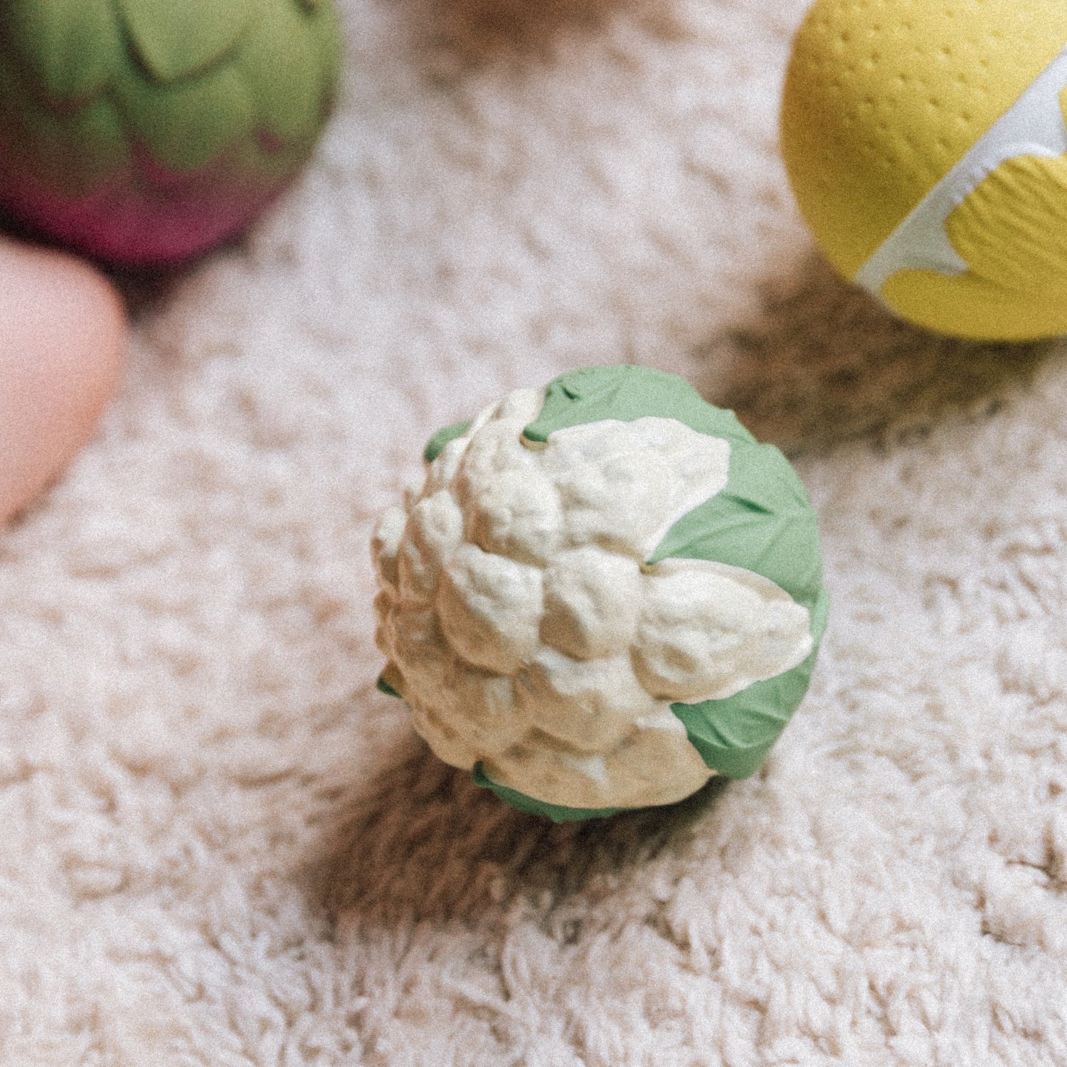 Dog toy shaped like a cauliflower on a soft surface