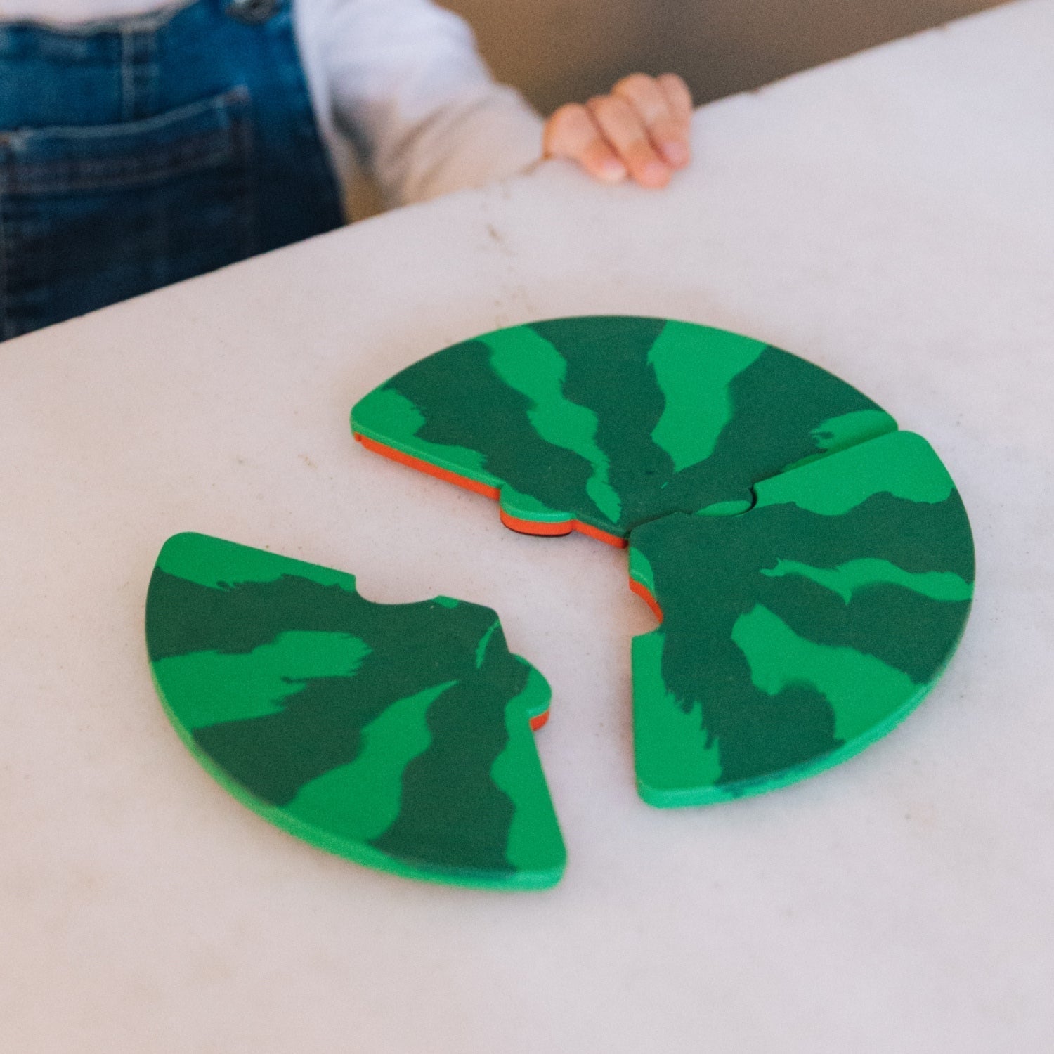Green camouflage-patterned object on a white surface