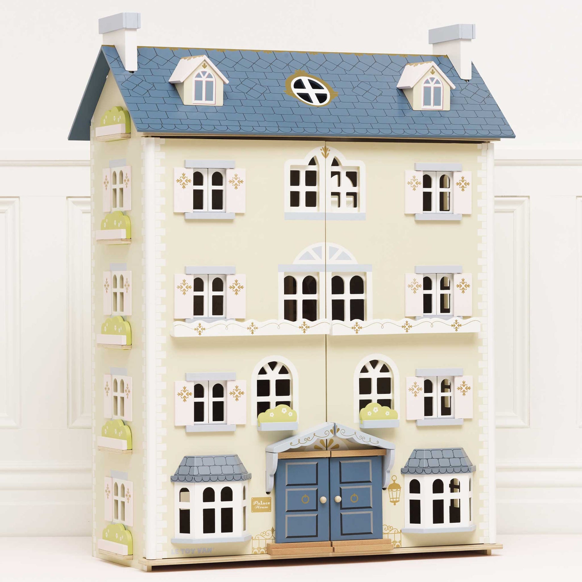 Toy dollhouse with blue roof and white walls on a white background