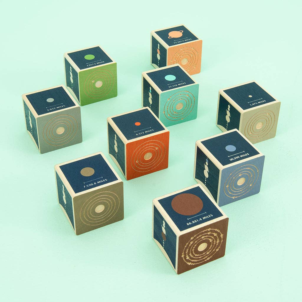 Set of colorful wooden blocks with planetary designs on a light green background