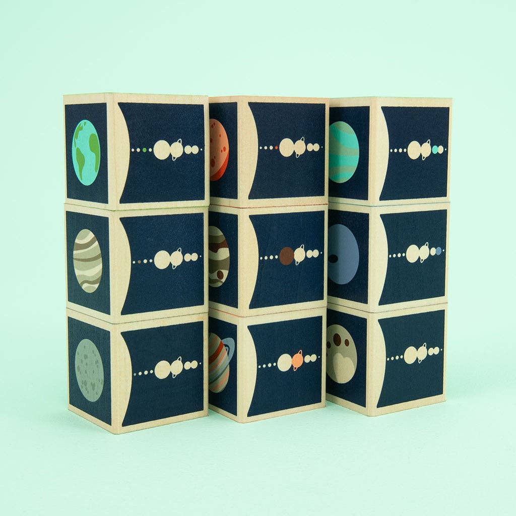 Set of wooden blocks with planet illustrations on a light blue background