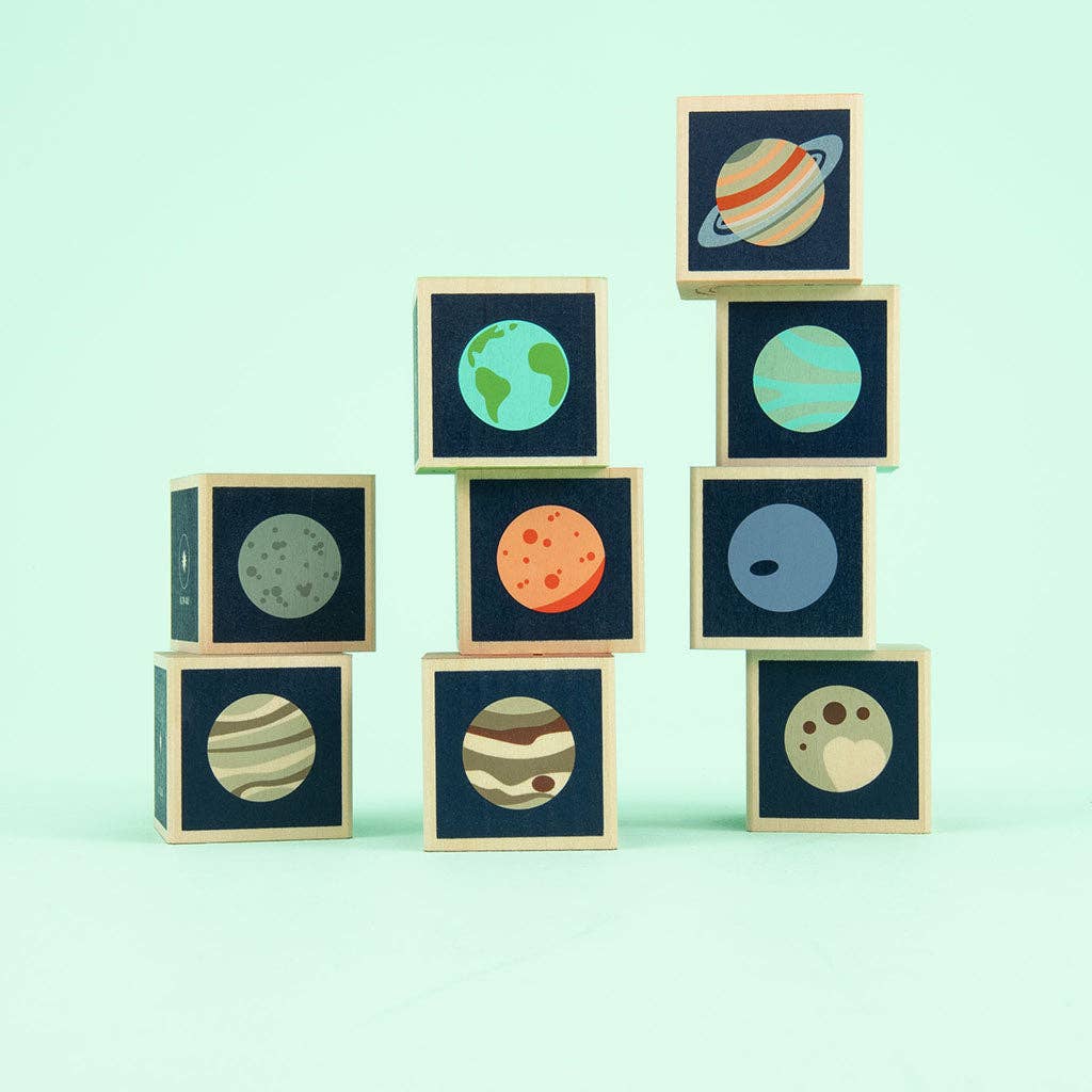 Wooden blocks with planet illustrations on a light green background