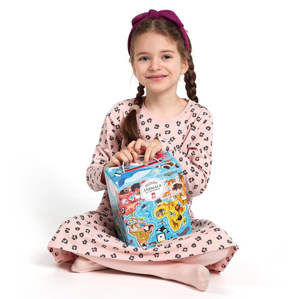Young girl holding a children's book with animal illustrations on a white background