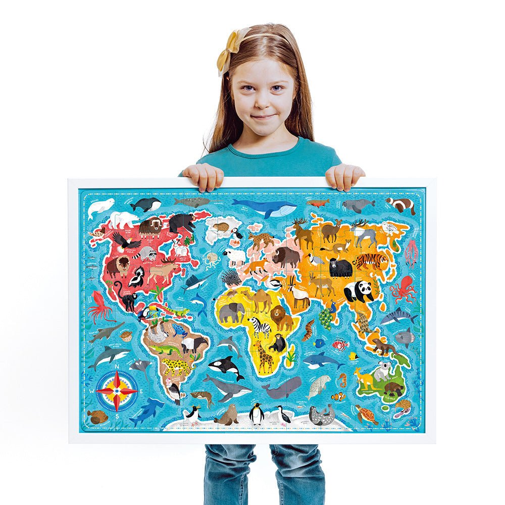 Child holding a colorful world map puzzle with animals on a white background