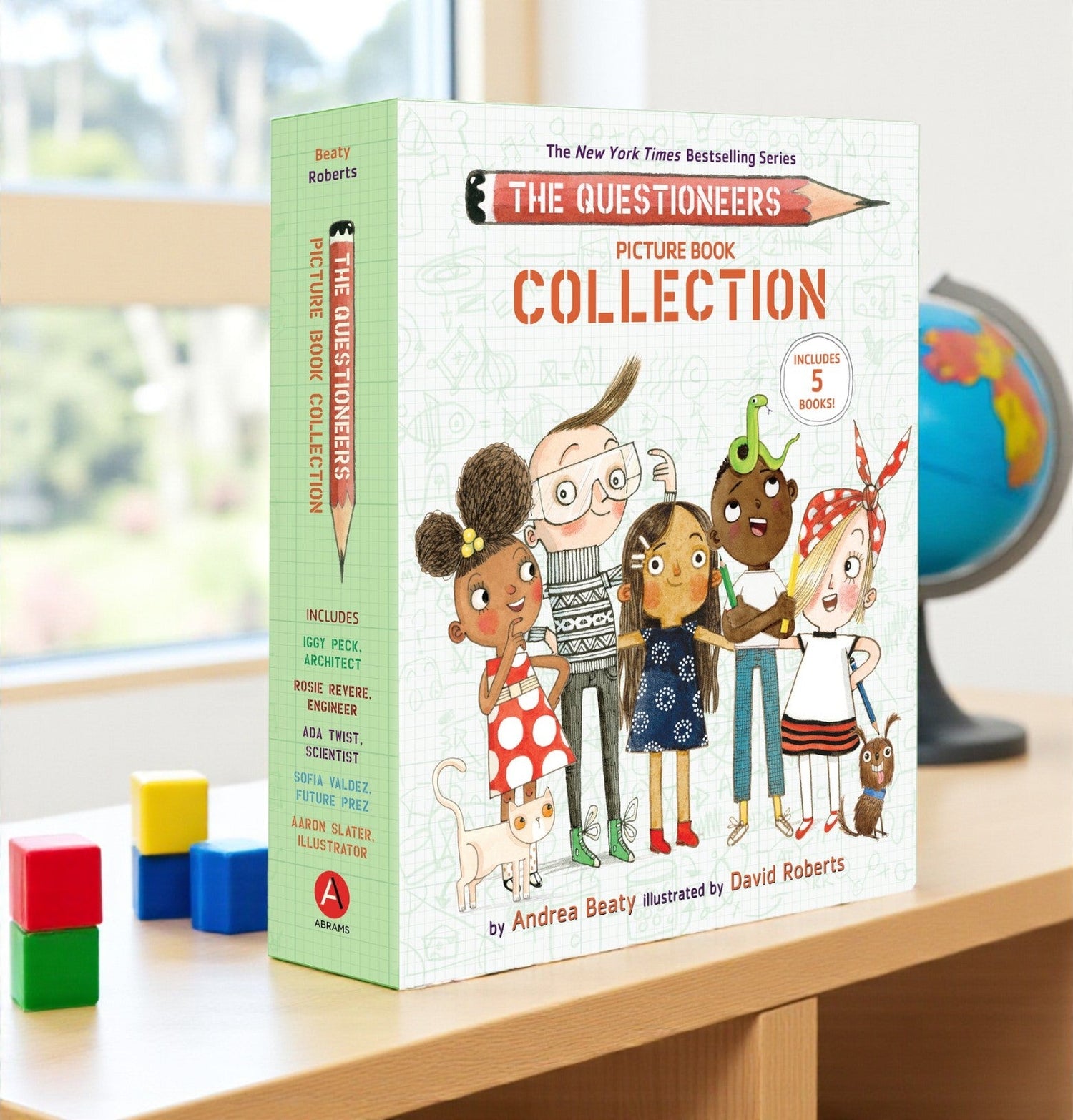 Book collection titled 'The Questioneers Picture Book Collection' on a table with educational items in the background.