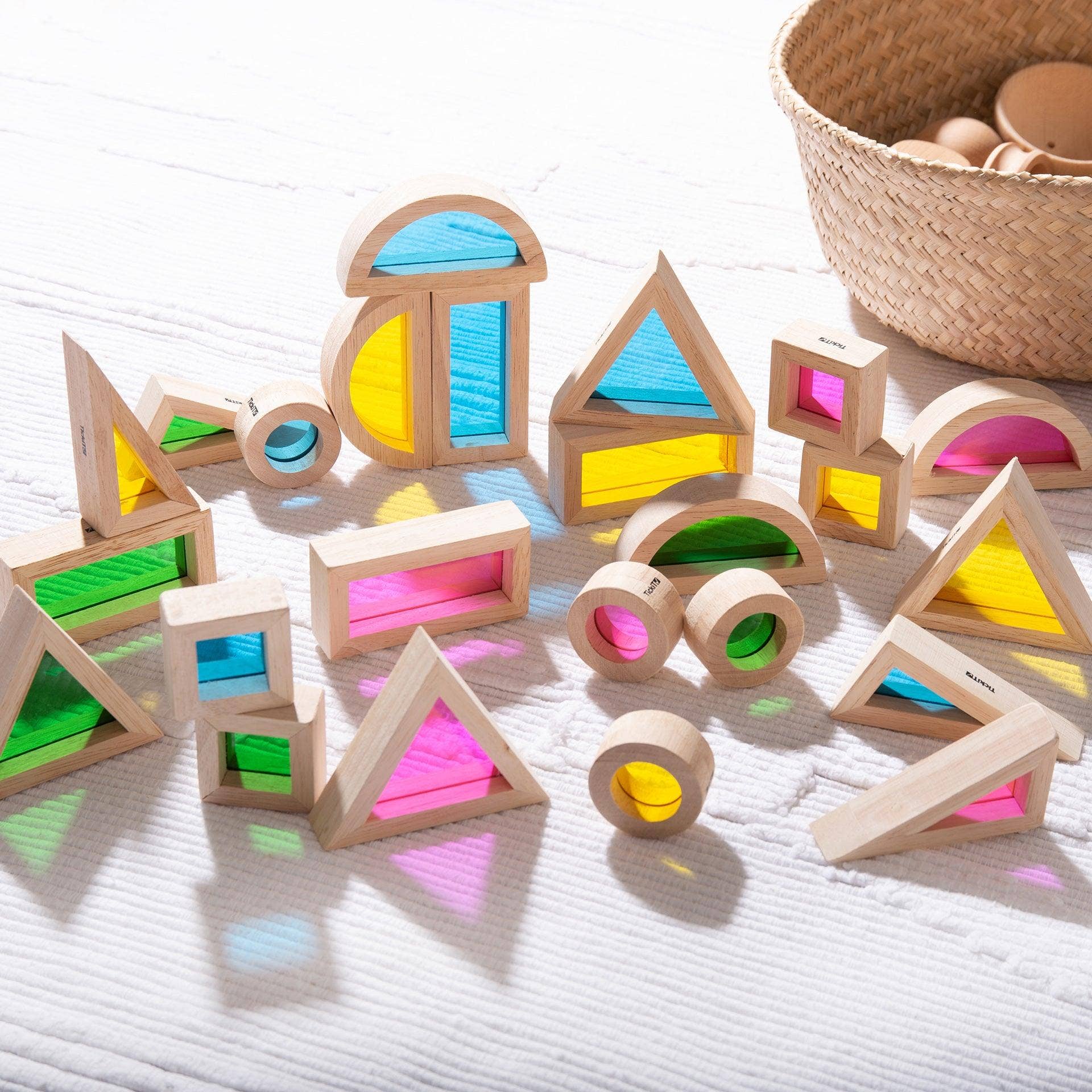 Colorful wooden geometric blocks on a light surface with a woven basket in the background.