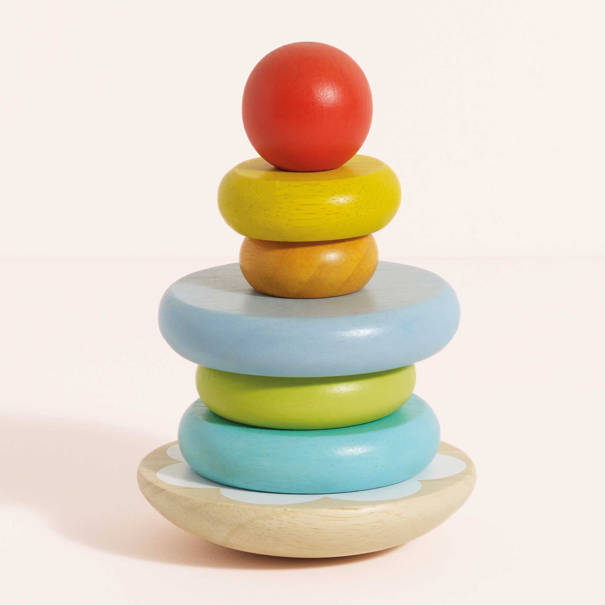 Colorful wooden stacking toy on a light pink background
