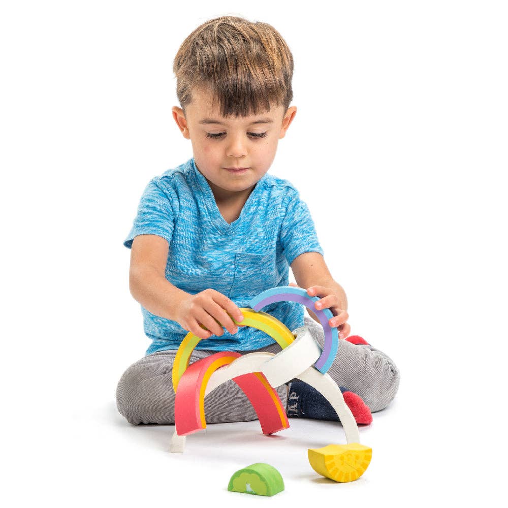 Child playing with a colorful toy on a white background